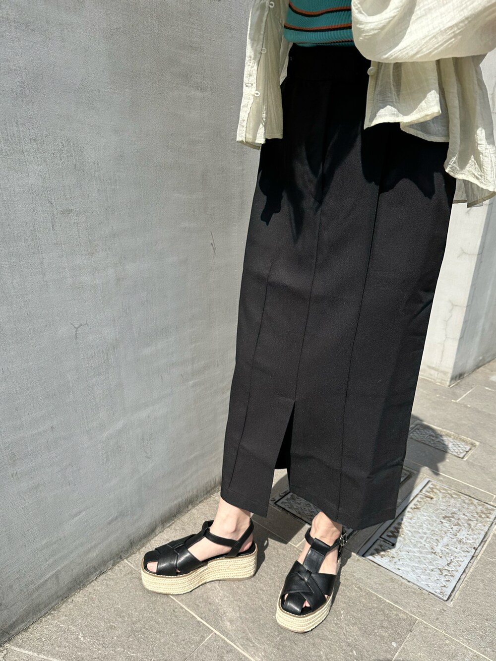 ブルー系のタンクトップ、ホワイト系のシャツ/ブラウス、ブラック系のスカートを着用したレディースの春コーディネートの4枚目の写真