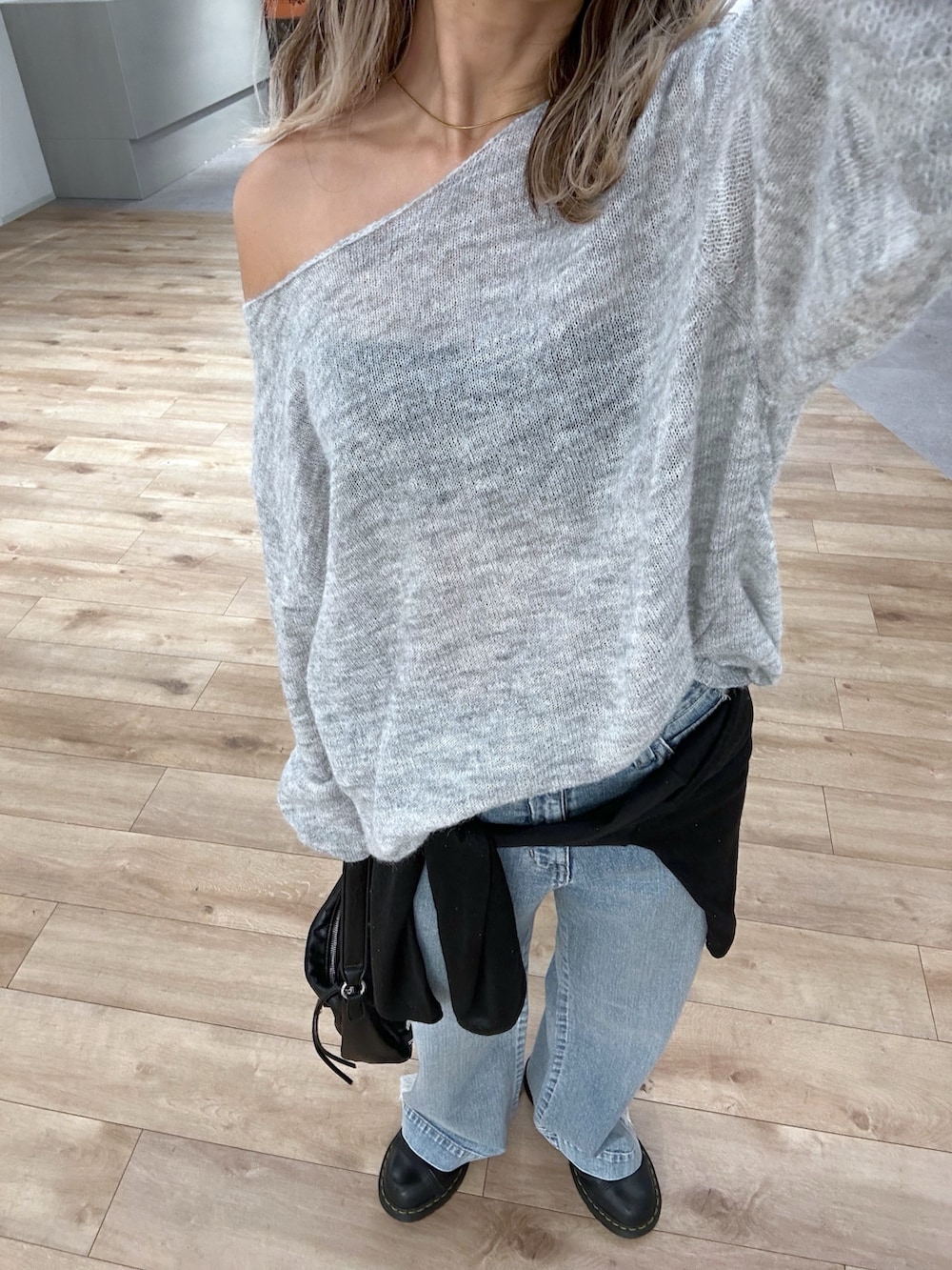 グレー系のニット/セーター、ブラック系のショルダーバッグ、ブラック系のTシャツ/カットソーを着用したレディースの秋コーディネートの5枚目の写真