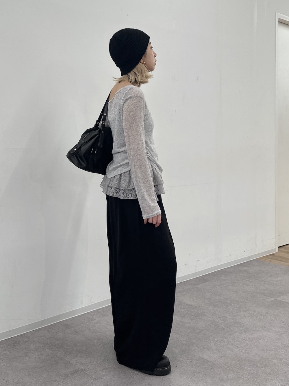 グレー系のTシャツ/カットソー、ブラック系のスラックスを着用したレディースの冬コーディネートの2枚目の写真