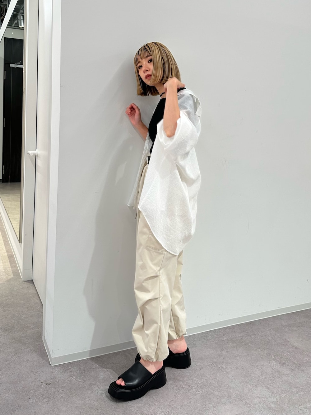 ブラック系のニット/セーター、ホワイト系のシャツ/ブラウス、ベージュ系のカーゴパンツを着用したレディースの夏コーディネートの2枚目の写真