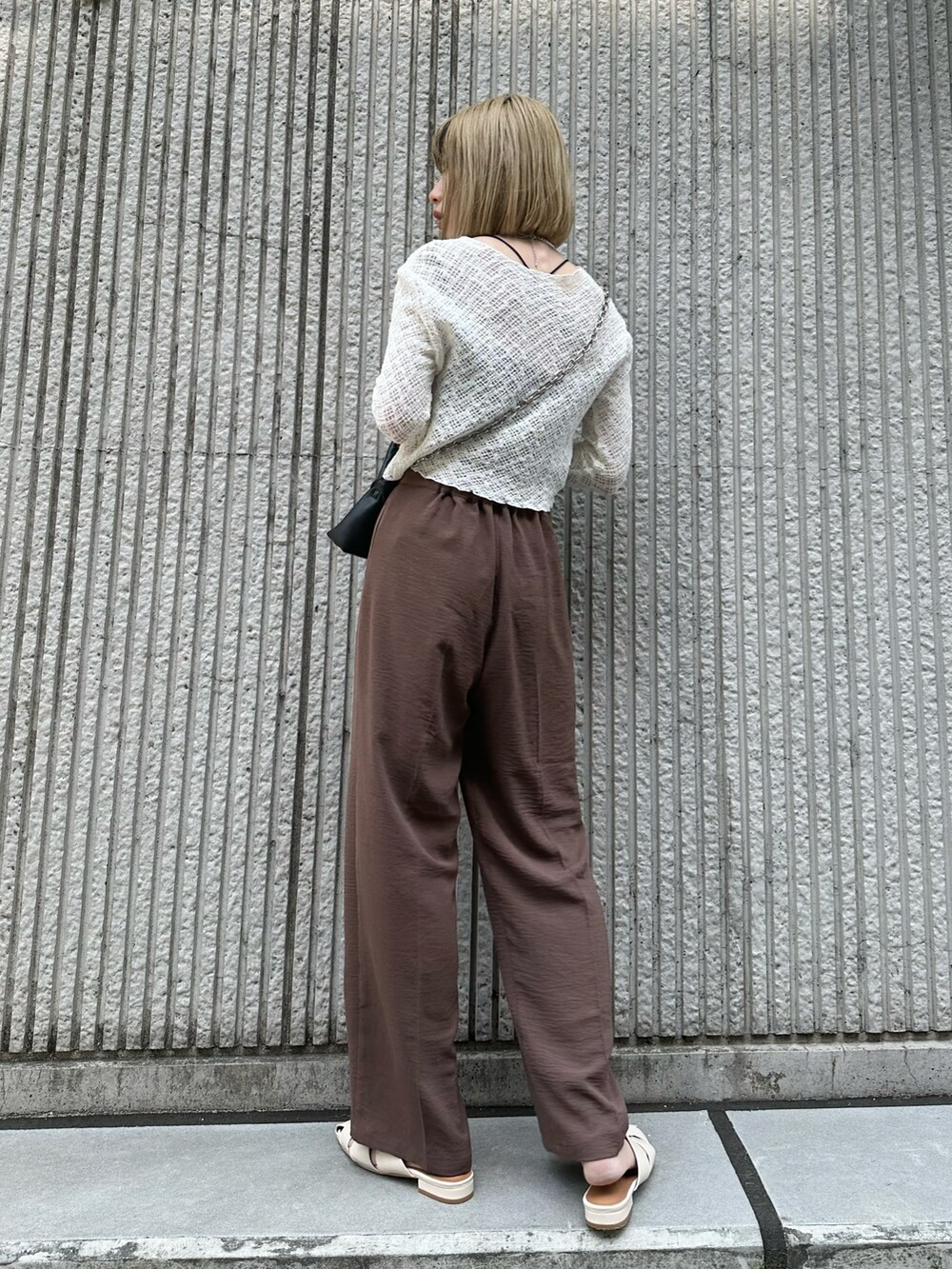ブラウン系のその他パンツ、ホワイト系のカーディガン/ボレロ、ブラック系のトートバッグを着用したレディースの春コーディネートの3枚目の写真