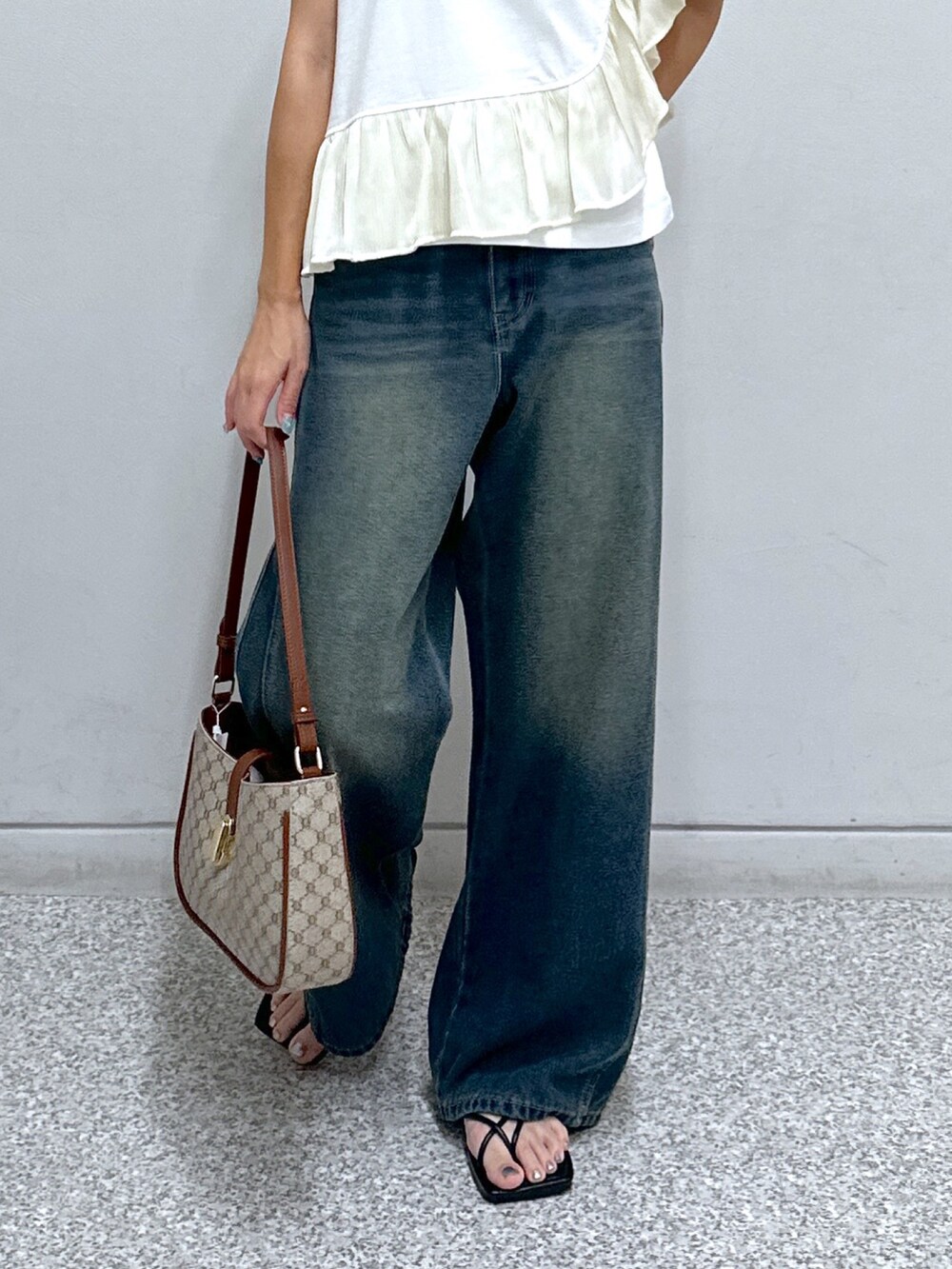 ブルー系のデニムパンツ、ホワイト系のTシャツ/カットソー、ベージュ系のショルダーバッグを着用したレディースの夏コーディネートの5枚目の写真