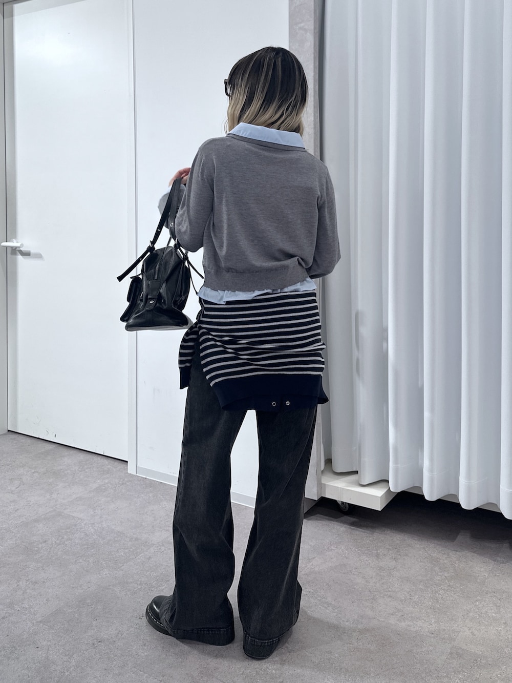 グレー系のニット/セーター、ブルー系のニット/セーター、ブラック系のデニムパンツを着用したレディースの春コーディネートの3枚目の写真