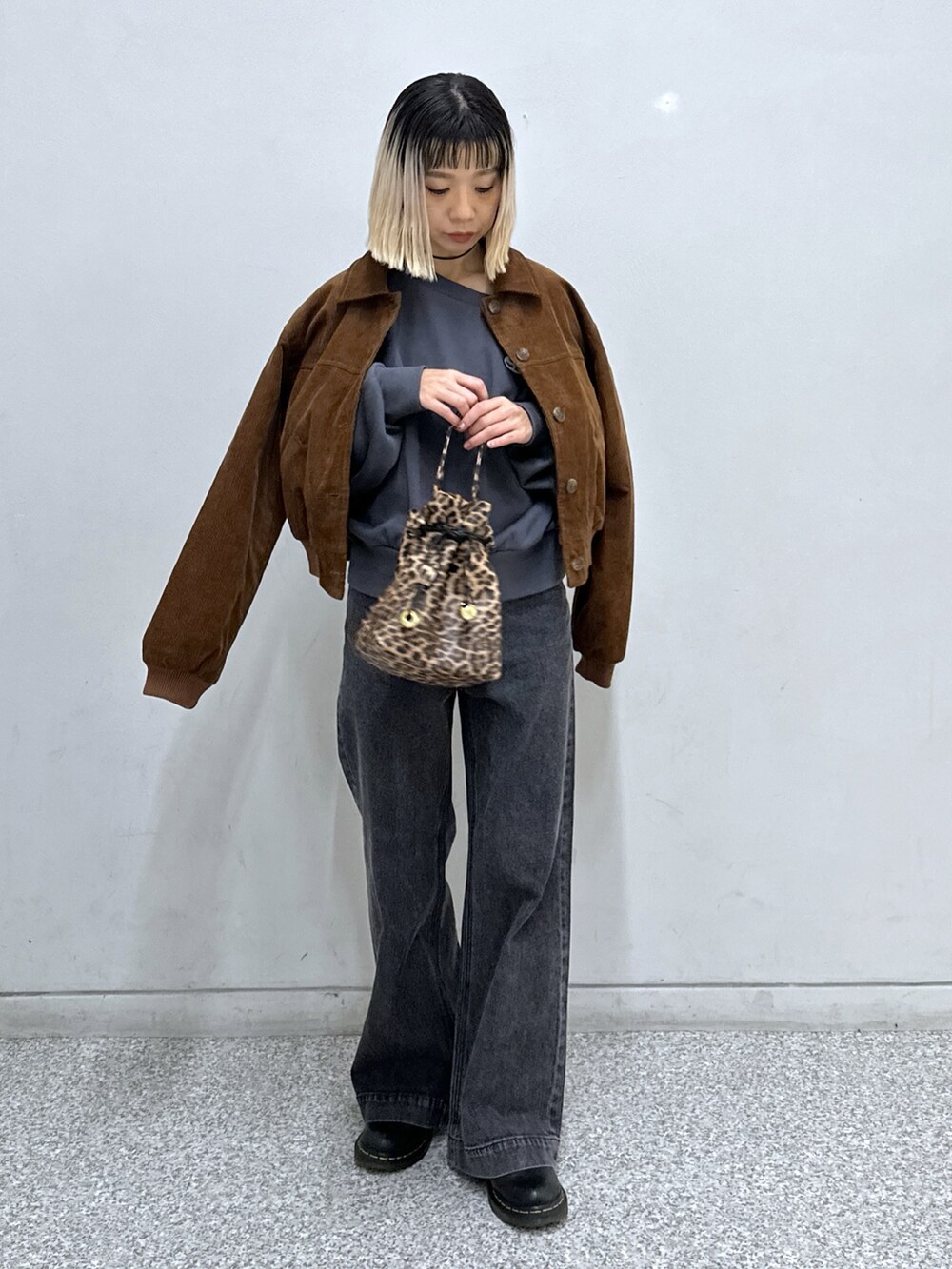 ブラック系のTシャツ/カットソー、ブラック系のデニムパンツ、ブラウン系のブルゾンを着用したレディースの秋コーディネートの4枚目の写真