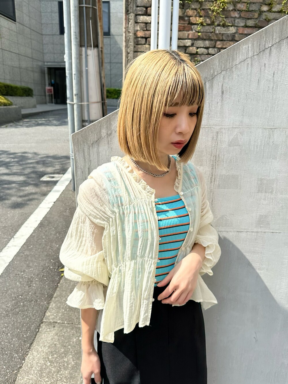 ブルー系のタンクトップ、ホワイト系のシャツ/ブラウス、ブラック系のスカートを着用したレディースの春コーディネートの3枚目の写真