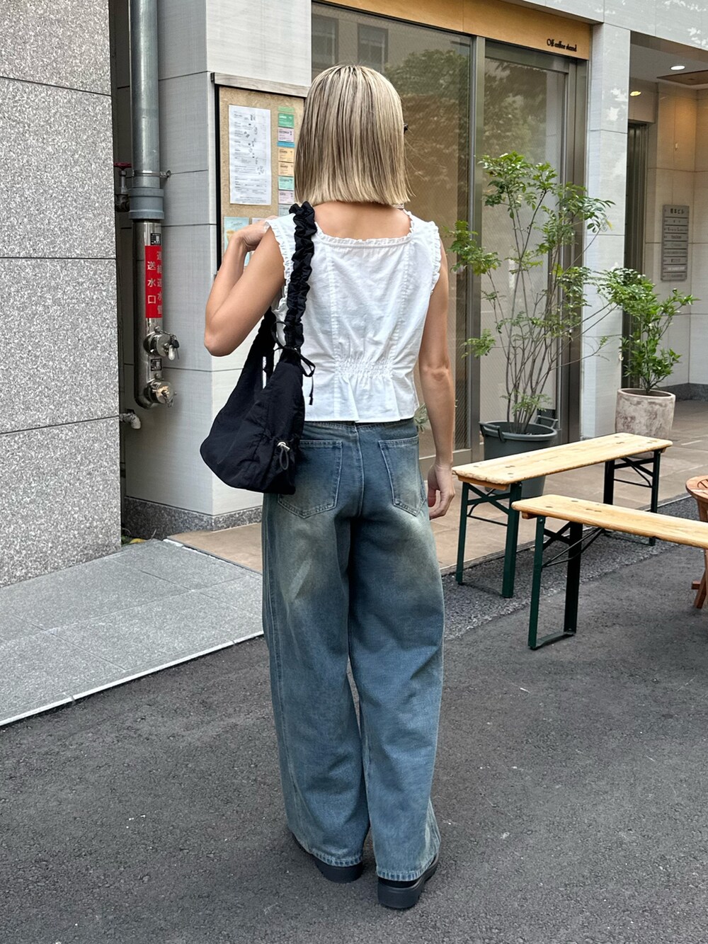 ホワイト系のシャツ/ブラウス、ブルー系のデニムパンツ、ブラック系のハンドバッグを着用したレディースの夏コーディネートの3枚目の写真