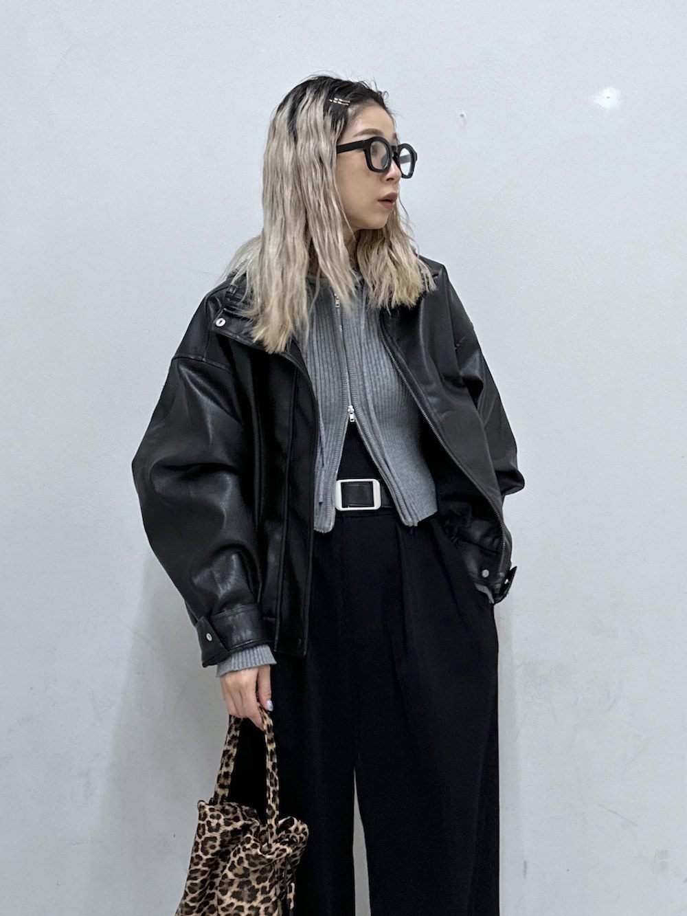 グレー系のニット/セーター、ブラック系のブルゾン、ブラック系のその他パンツを着用したレディースの秋コーディネートの4枚目の写真