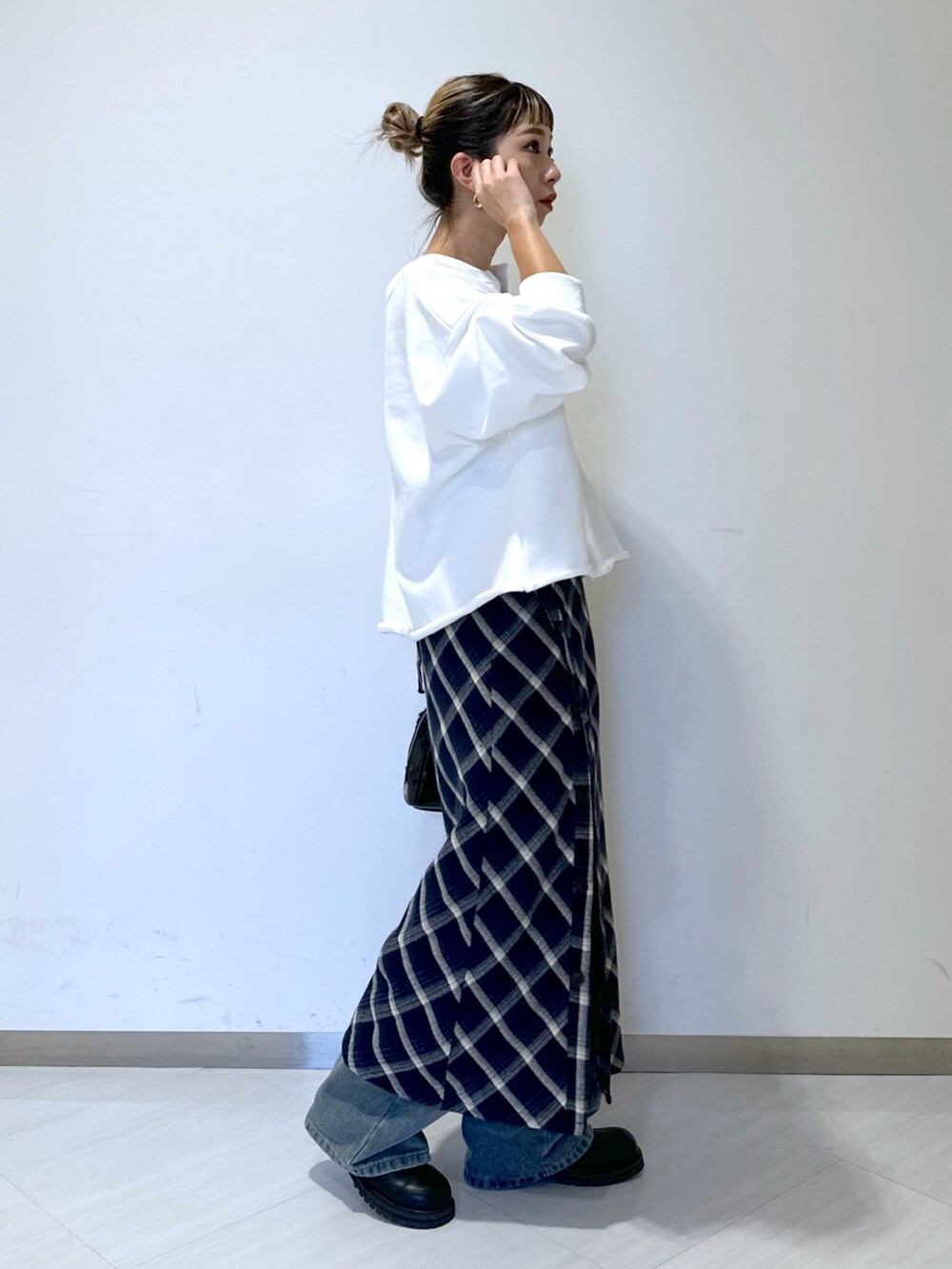 ホワイト系のスウェット、ブルー系のデニムパンツ、ブルー系のワンピースを着用したレディースの冬コーディネートの2枚目の写真