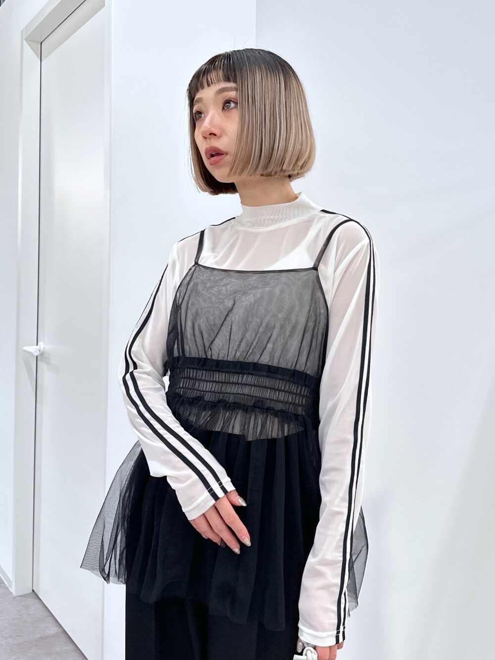 ホワイト系のブルゾン、ブラック系のシャツ/ブラウス、ホワイト系のTシャツ/カットソーを着用したレディースの冬コーディネートの5枚目の写真