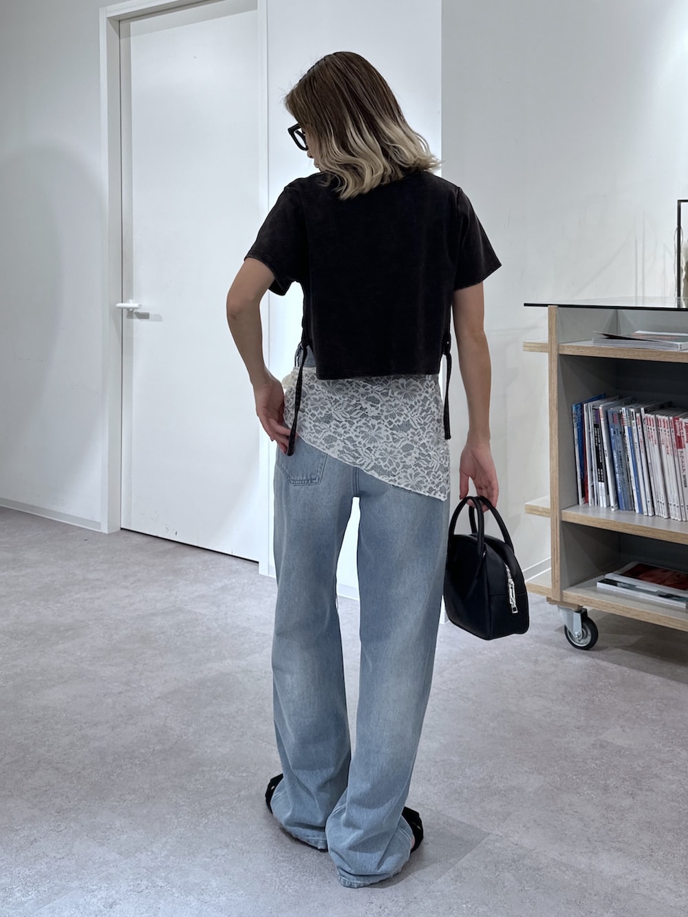 ブラック系のTシャツ/カットソー、ブルー系のデニムパンツ、ブラック系のハンドバッグを着用したレディースの夏コーディネートの3枚目の写真