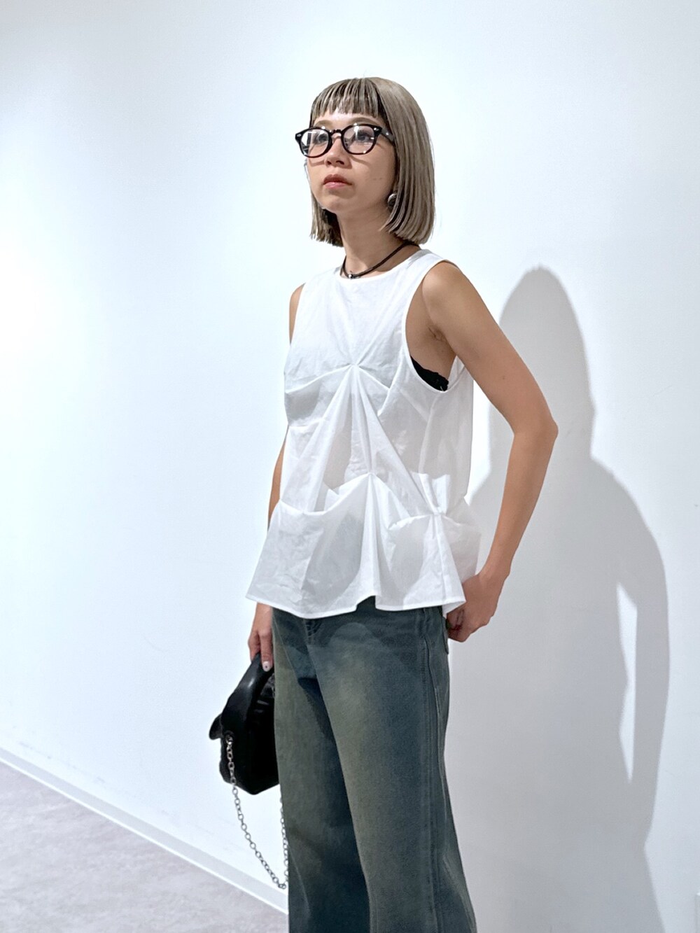 ホワイト系のシャツ/ブラウス、ブルー系のデニムパンツ、ブラック系のショルダーバッグを着用したレディースの夏コーディネートの4枚目の写真