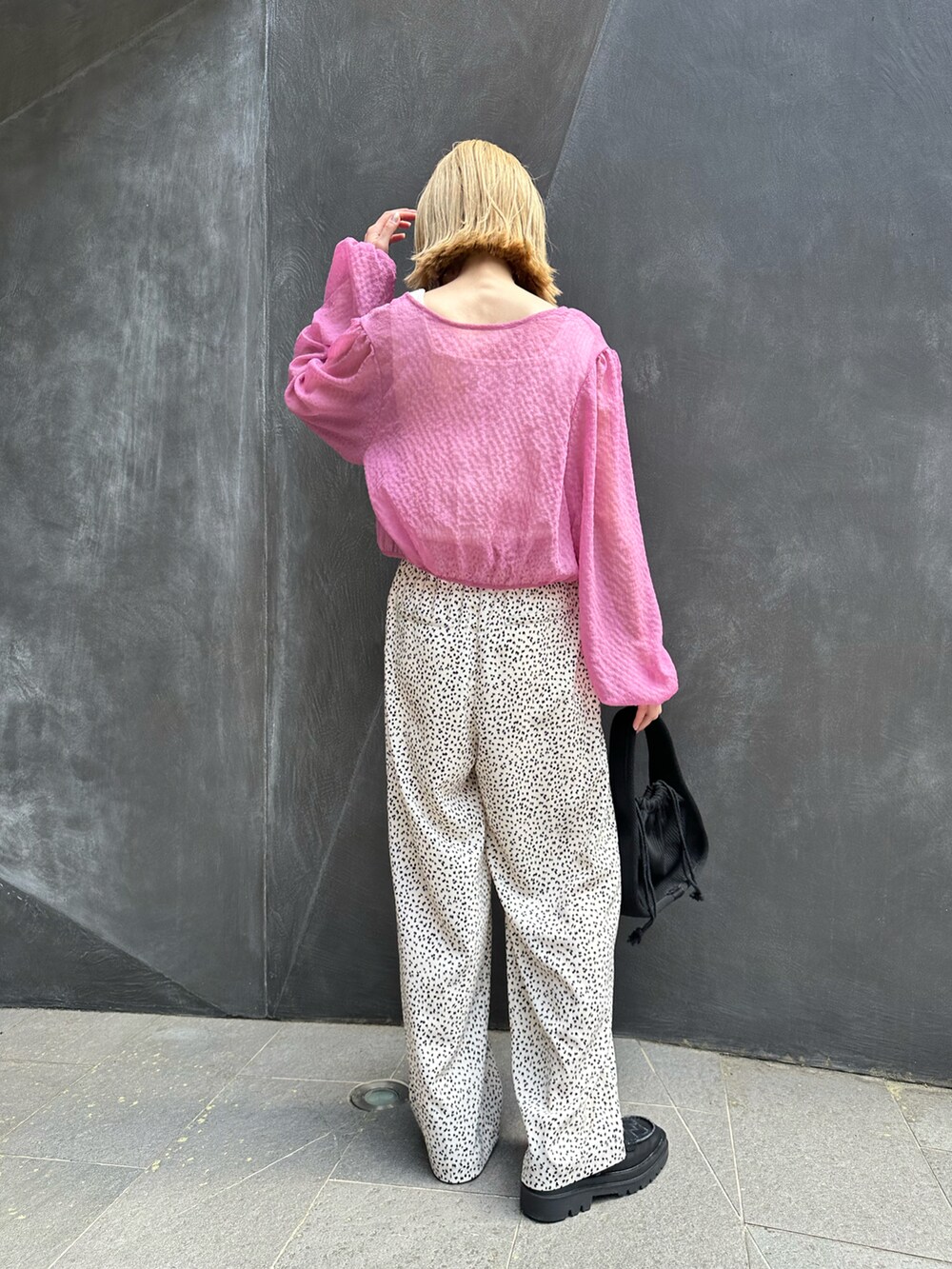 ピンク系のシャツ/ブラウス、ホワイト系のその他パンツ、ブラック系のトートバッグを着用したレディースの春コーディネートの2枚目の写真