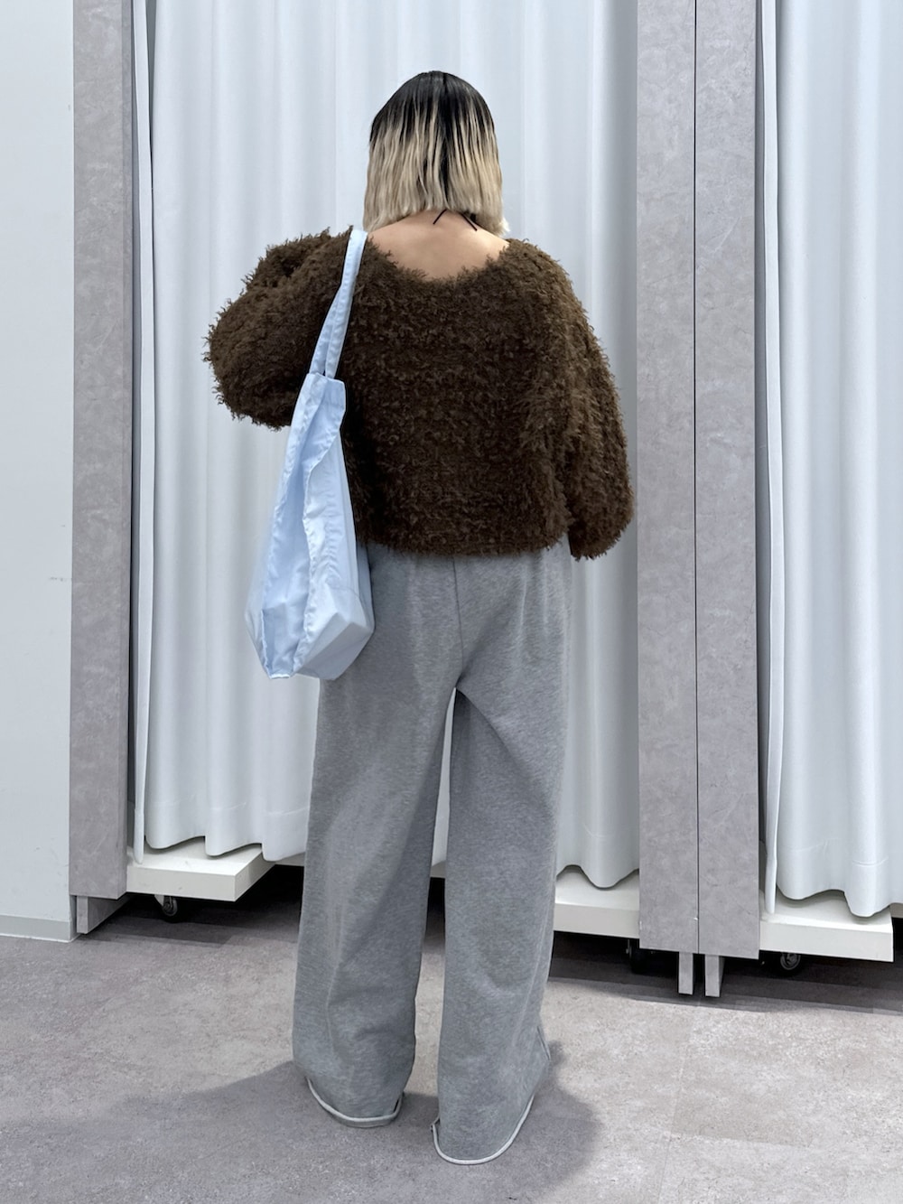 ブラウン系のTシャツ/カットソー、グレー系のその他パンツ、ブルー系のトートバッグを着用したレディースの冬コーディネートの3枚目の写真