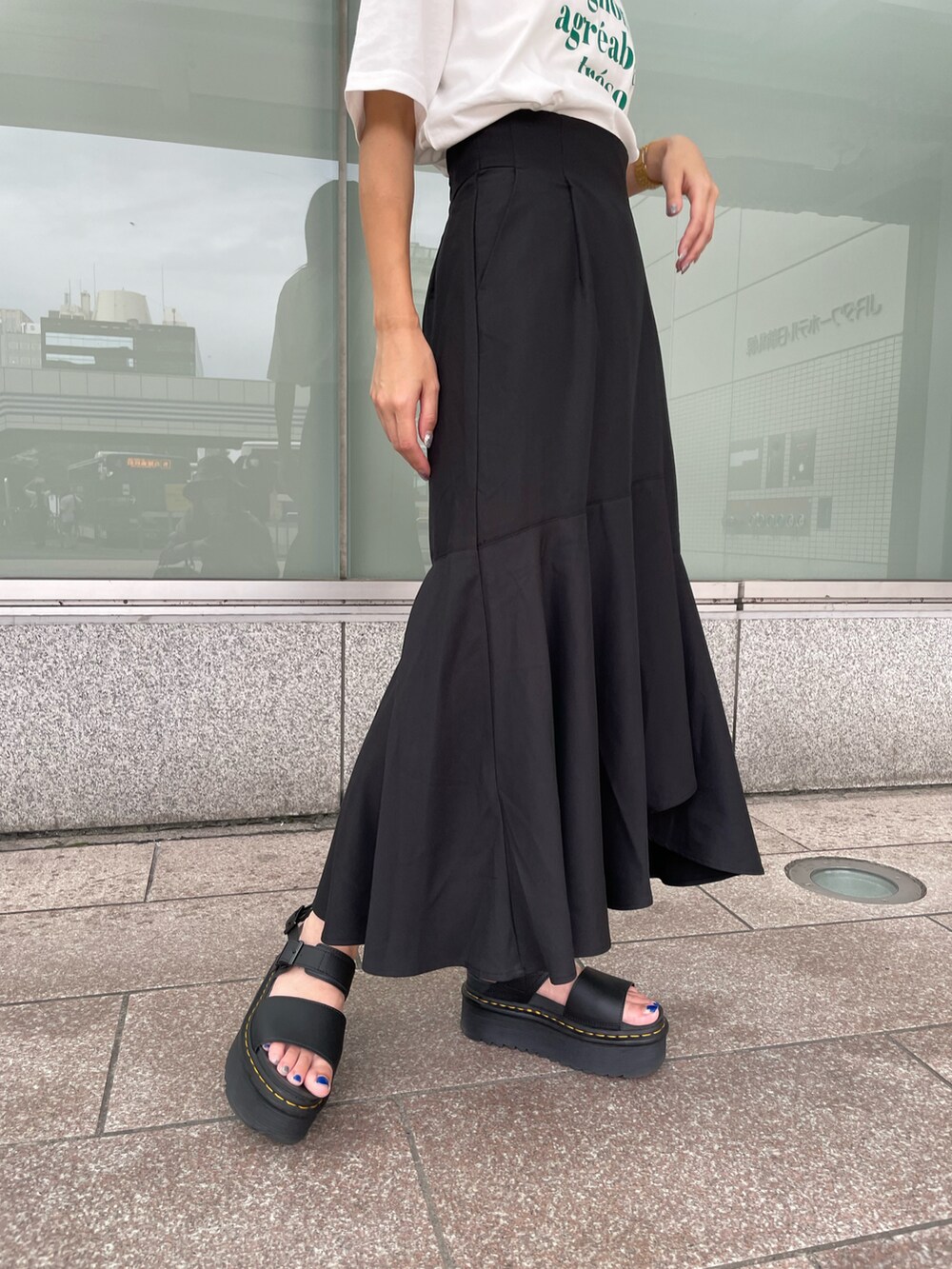 ブラック系のスカート、ホワイト系のTシャツ/カットソー、ブラック系のハットを着用したレディースの夏コーディネートの3枚目の写真