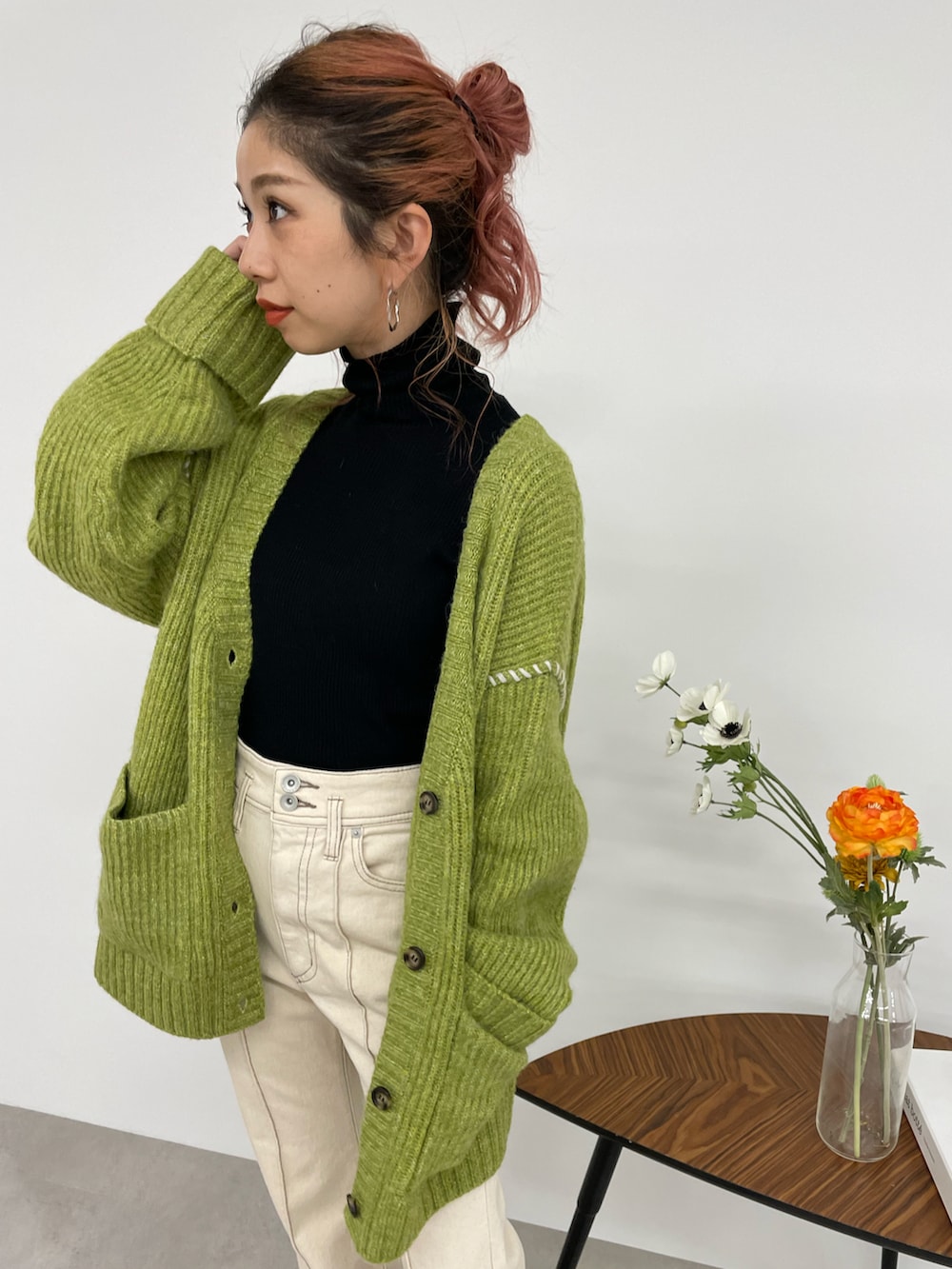 ホワイト系のデニムパンツ、グリーン系のカーディガン/ボレロ、ブラック系のニット/セーターを着用したレディースの秋コーディネートの4枚目の写真