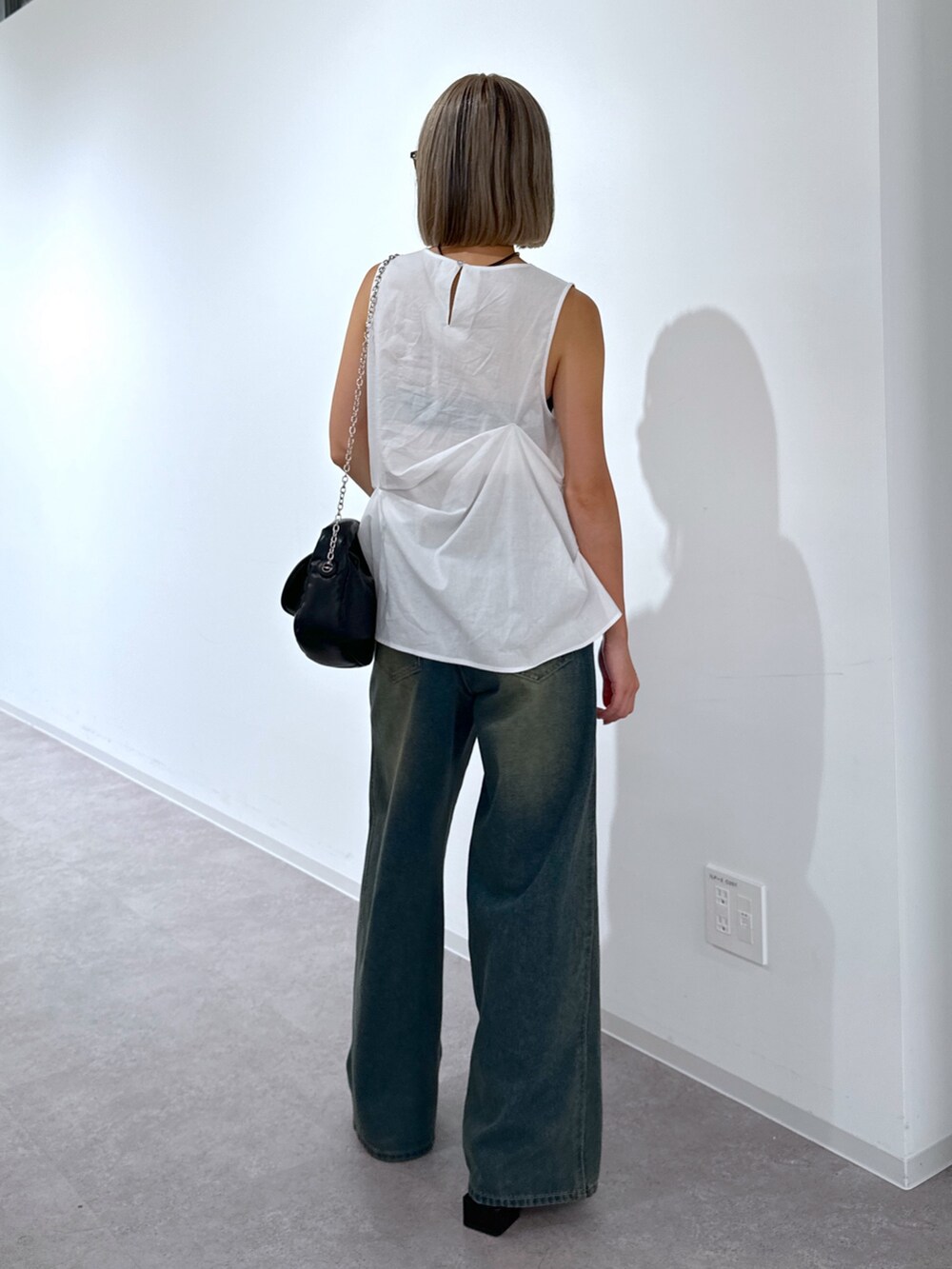 ホワイト系のシャツ/ブラウス、ブルー系のデニムパンツ、ブラック系のショルダーバッグを着用したレディースの夏コーディネートの3枚目の写真