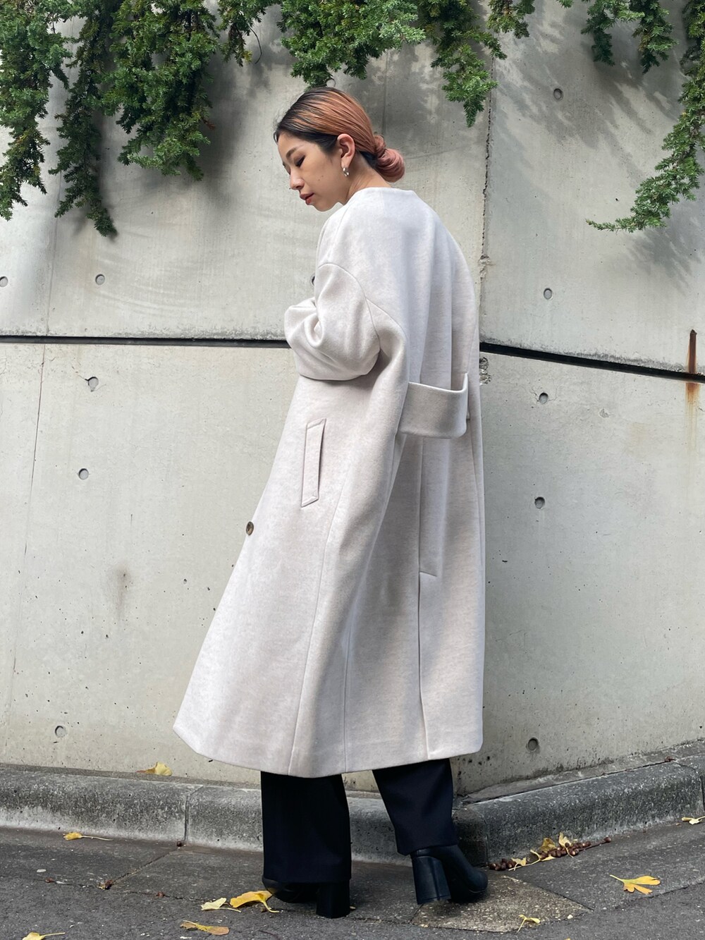 ブラック系のその他パンツ、ブラック系のブーツ、ベージュ系のノーカラーコートを着用したレディースの秋コーディネートの3枚目の写真