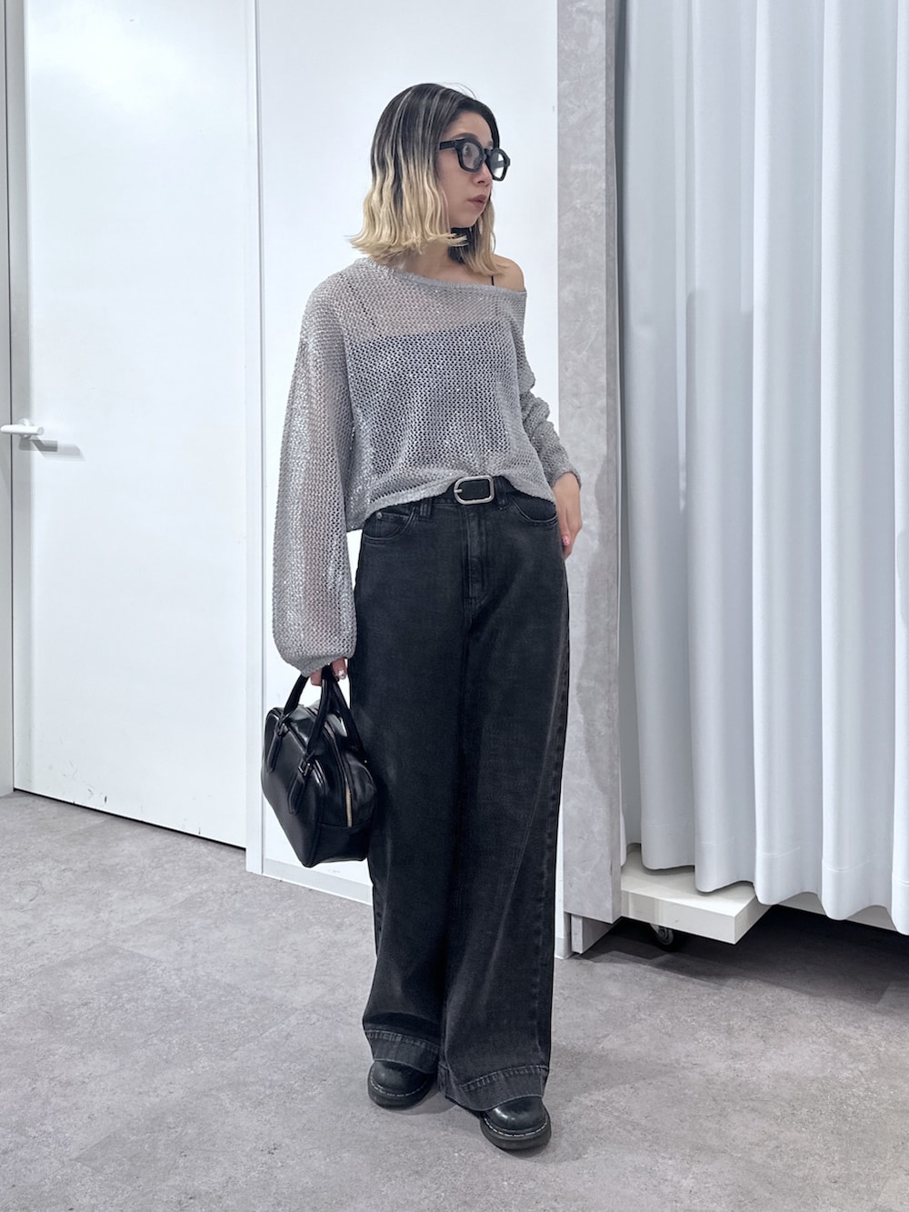 ブラック系のデニムパンツ、グレー系のニット/セーター、ブラック系のキャミソールを着用したレディースの春コーディネートの7枚目の写真