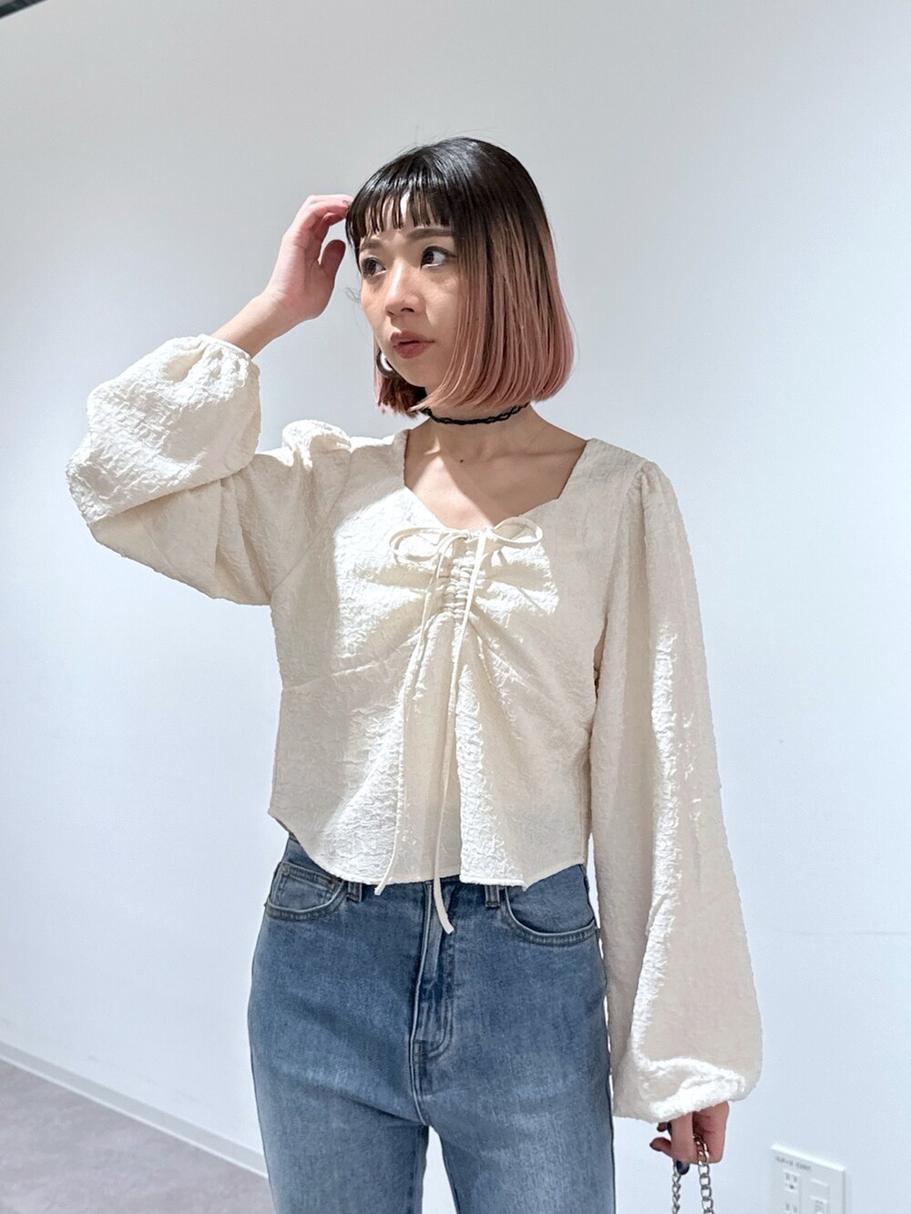 ホワイト系のシャツ/ブラウス、ブルー系のデニムパンツ、ブラック系のショルダーバッグを着用したレディースの冬コーディネートの5枚目の写真