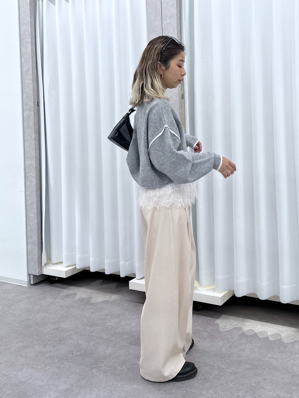 グレー系のニット/セーター、ホワイト系のTシャツ/カットソー、ホワイト系のその他パンツを着用したレディースの夏コーディネートの2枚目の写真