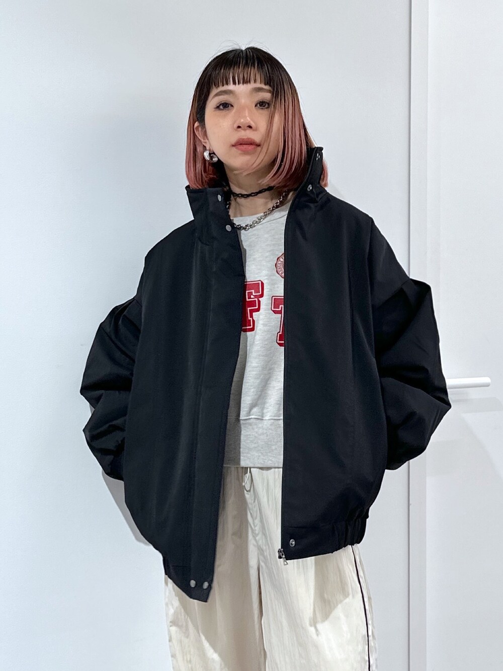 ブラック系のブルゾン、ホワイト系のスウェット、ホワイト系のその他パンツを着用したレディースの冬コーディネートの5枚目の写真