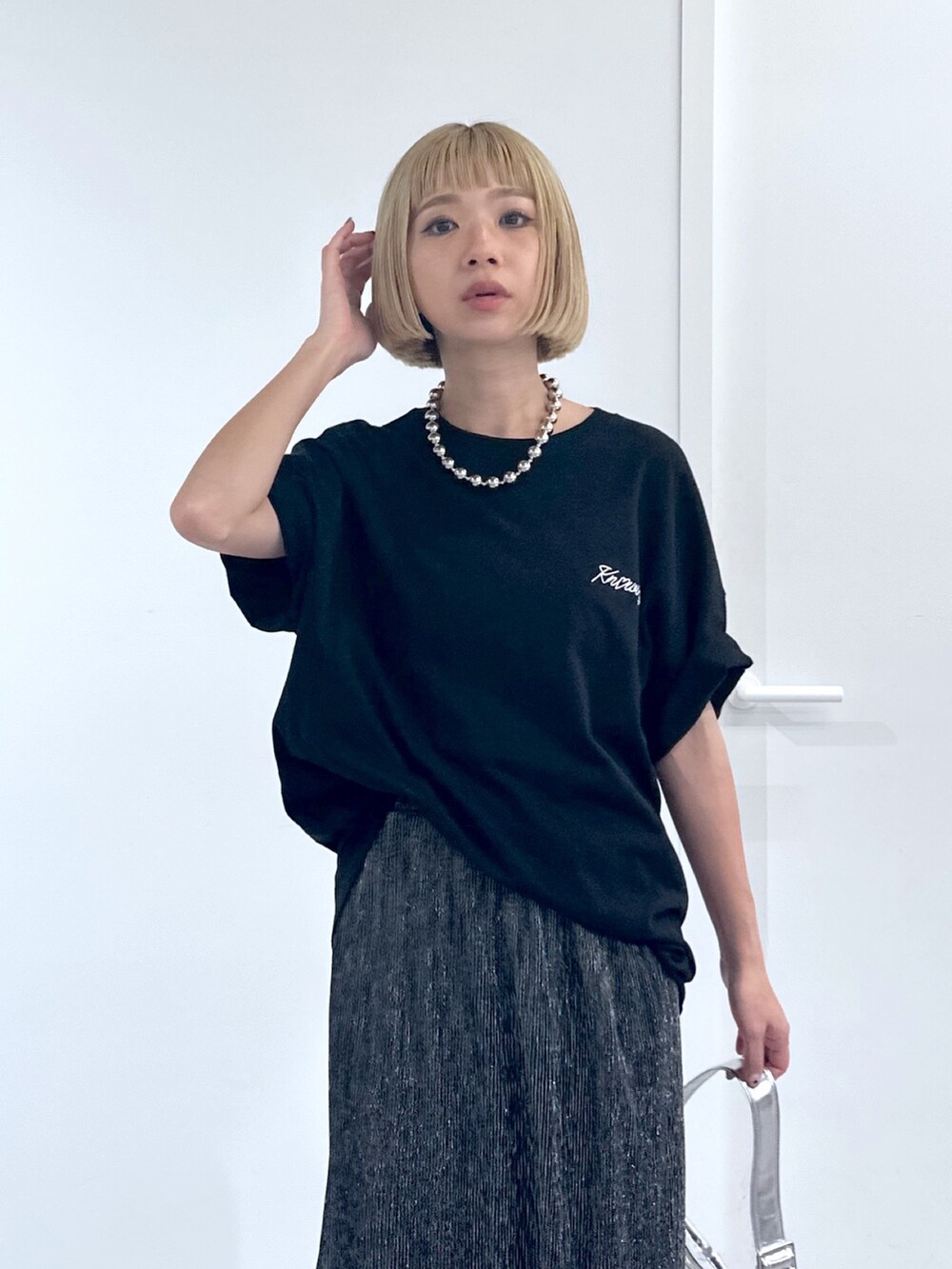 ブラック系のTシャツ/カットソー、ブラック系のスカート、シルバー系のショルダーバッグを着用したレディースの春コーディネートの4枚目の写真