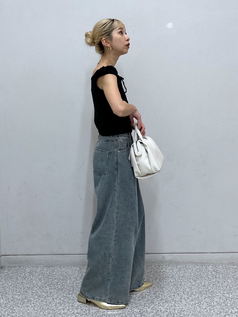 ブラック系のTシャツ/カットソー、ブルー系のデニムパンツ、ゴールド系のパンプスを着用したレディースの春コーディネートの2枚目の写真
