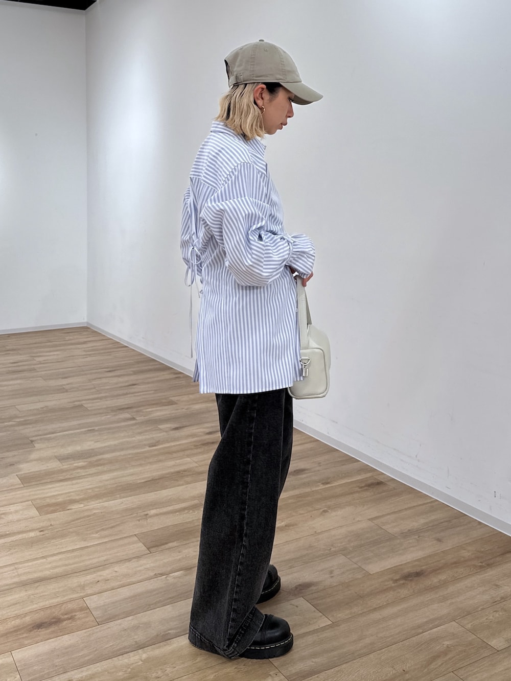 ブルー系のシャツ/ブラウス、ブラック系のデニムパンツ、ホワイト系のハンドバッグを着用したレディースの冬コーディネートの2枚目の写真