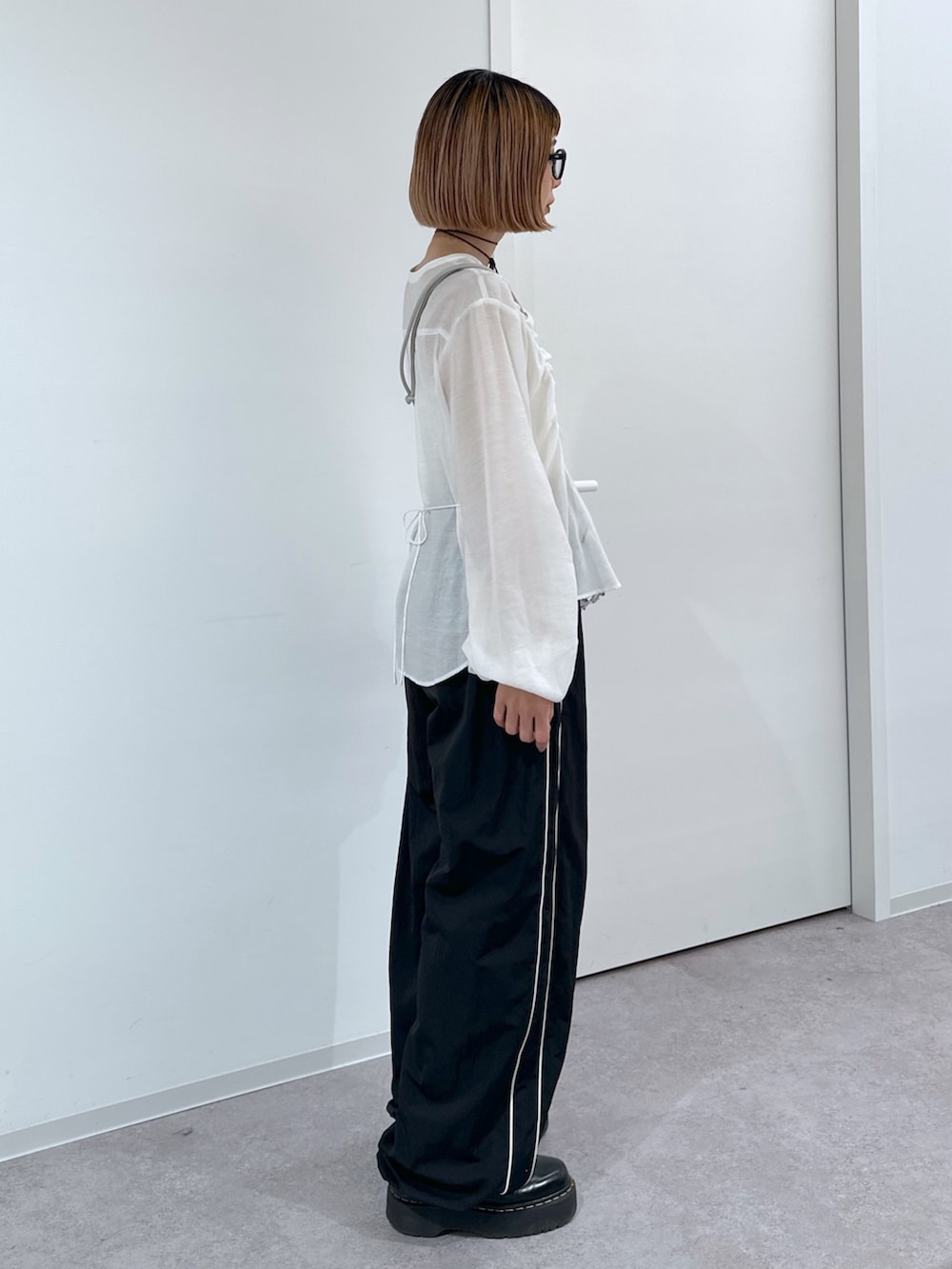 ブラック系のその他パンツ、シルバー系のハンドバッグ、ホワイト系のシャツ/ブラウスを着用したレディースの春コーディネートの3枚目の写真