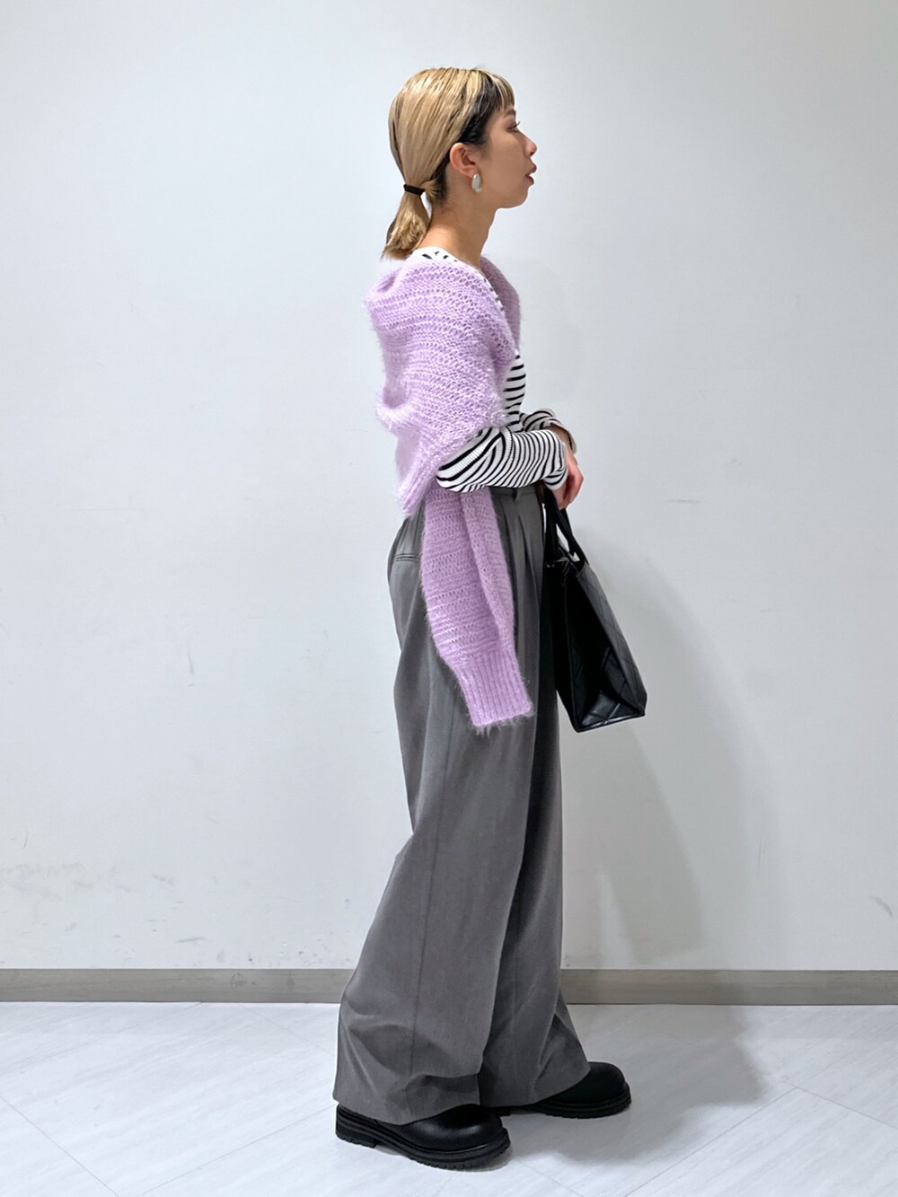 パープル系のニット/セーター、グレー系のスラックス、ホワイト系のニット/セーターを着用したレディースの秋コーディネートの2枚目の写真