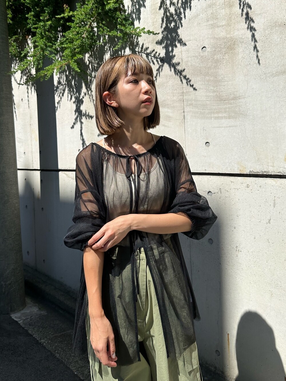 ブラック系のシャツ/ブラウス、グリーン系のカーゴパンツを着用したレディースの夏コーディネートの5枚目の写真