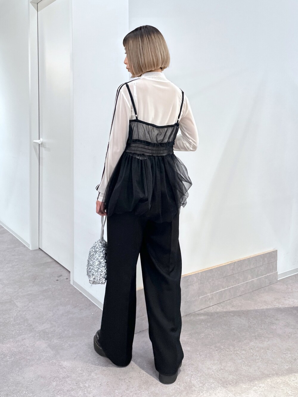 ホワイト系のブルゾン、ブラック系のシャツ/ブラウス、ホワイト系のTシャツ/カットソーを着用したレディースの冬コーディネートの4枚目の写真