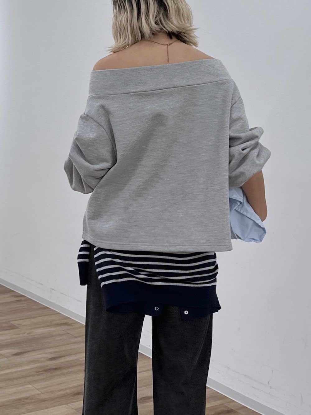 グレー系のTシャツ/カットソー、ブラック系のデニムパンツ、ブルー系のニット/セーターを着用したレディースの冬コーディネートの6枚目の写真