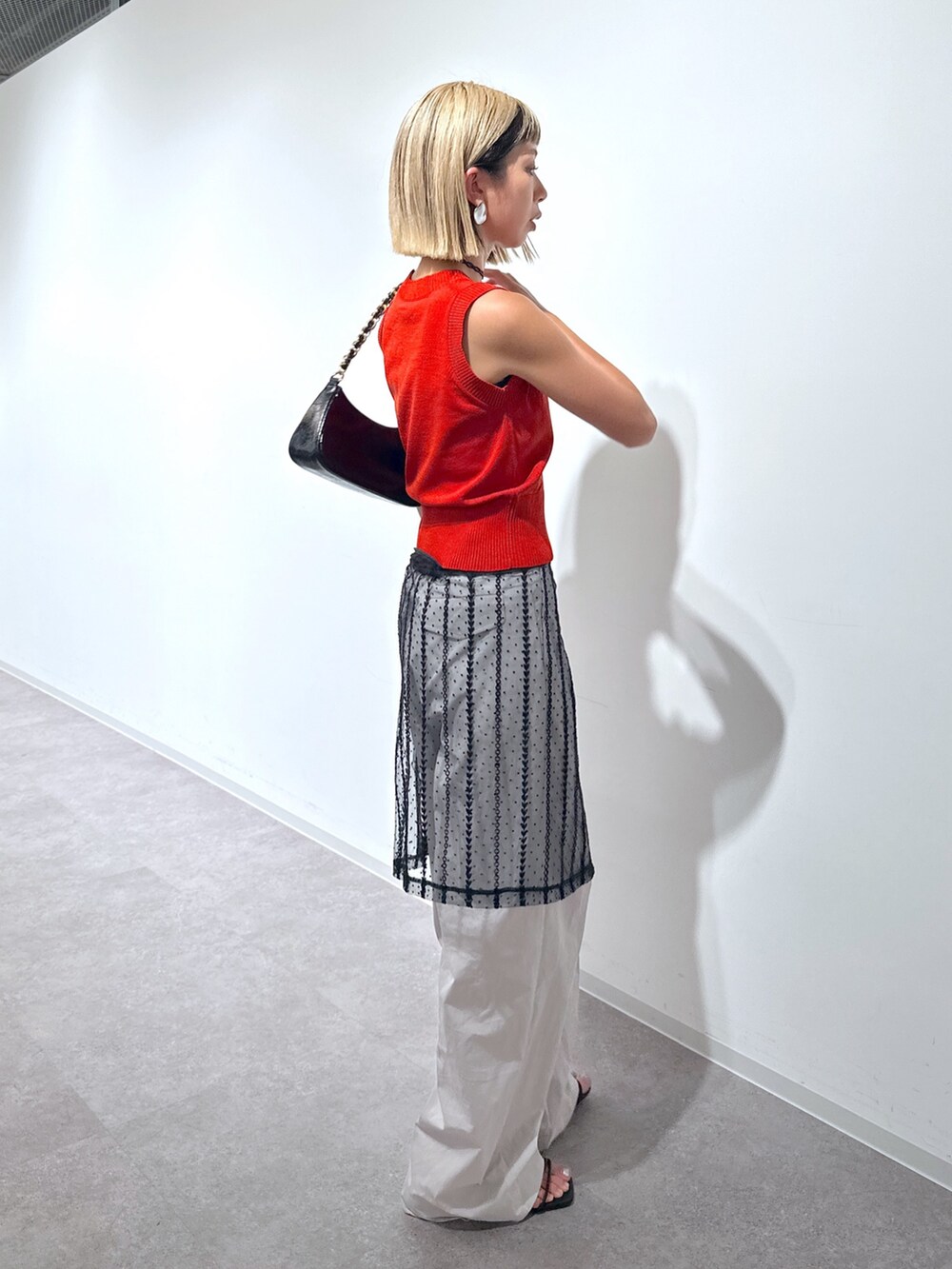 ブラック系のスカート、レッド系のニット/セーター、グレー系のその他パンツを着用したレディースの夏コーディネートの2枚目の写真