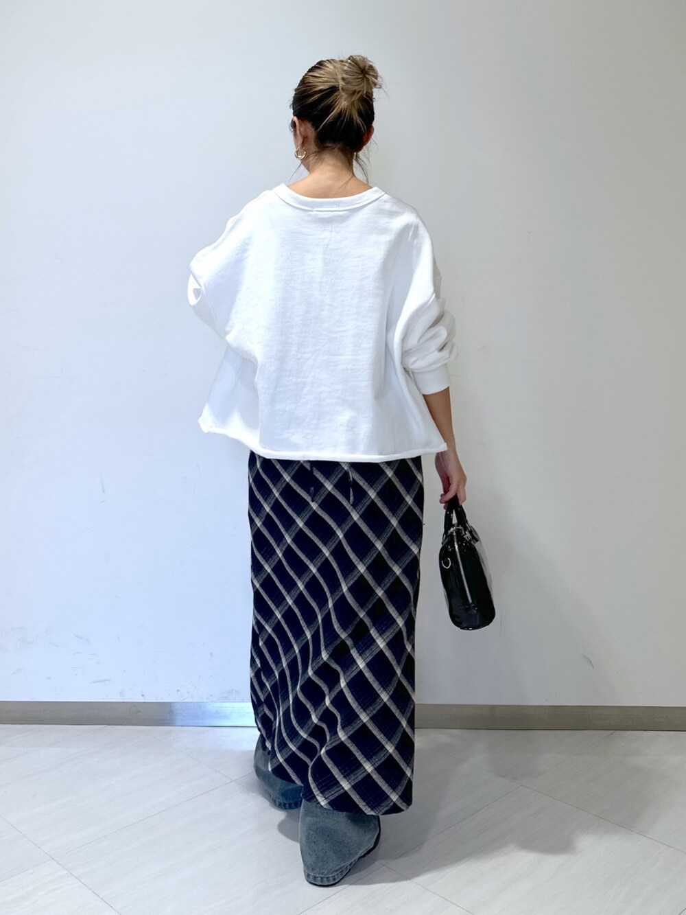 ホワイト系のスウェット、ブルー系のデニムパンツ、ブルー系のワンピースを着用したレディースの冬コーディネートの3枚目の写真