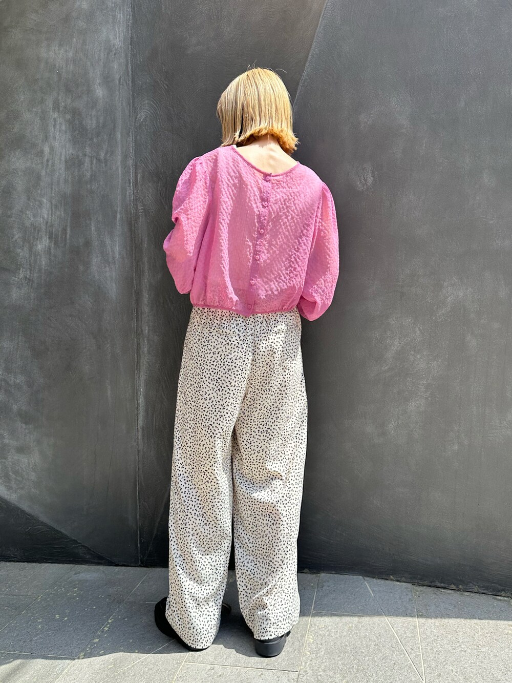 ピンク系のシャツ/ブラウス、ホワイト系のその他パンツ、ブラック系のトートバッグを着用したレディースの春コーディネートの5枚目の写真