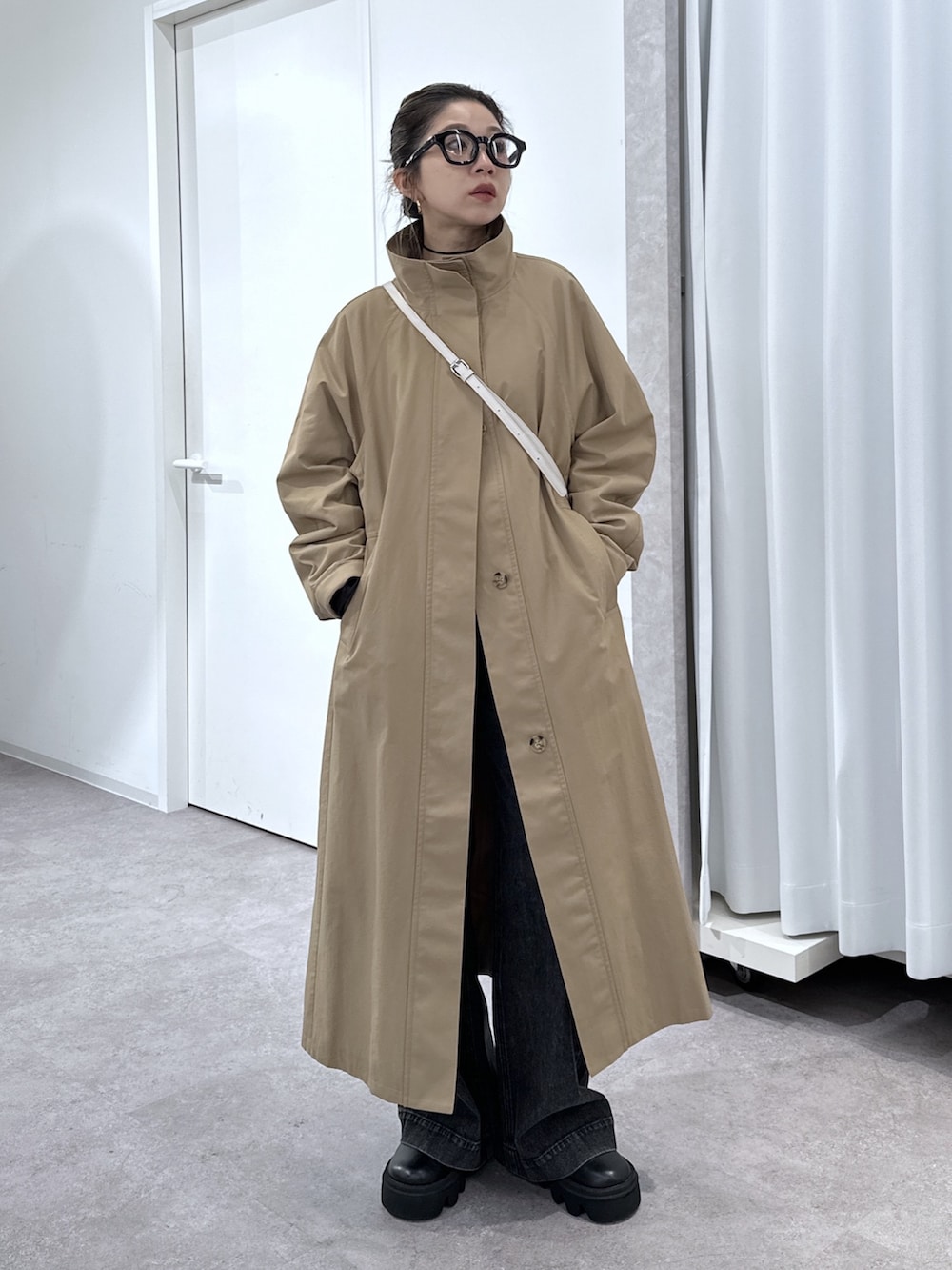 ブラック系のデニムパンツ、ブラック系のシャツ/ブラウス、ベージュ系のトレンチコートを着用したレディースの春コーディネートの4枚目の写真