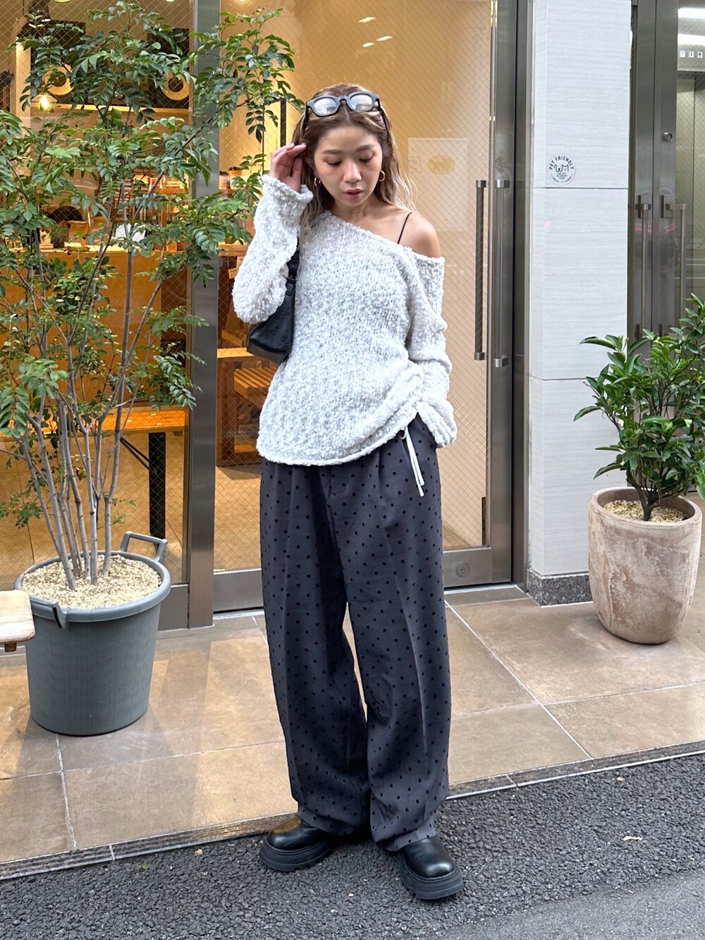 グレー系のニット/セーター、ブラック系のブルゾン、ブラック系のショルダーバッグを着用したレディースの秋コーディネートの8枚目の写真