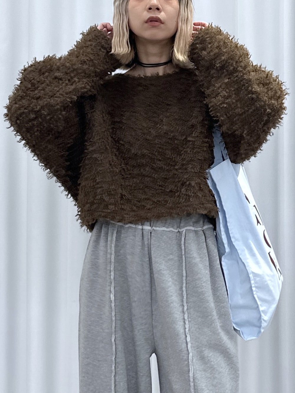 ブラウン系のTシャツ/カットソー、グレー系のその他パンツ、ブルー系のトートバッグを着用したレディースの冬コーディネートの4枚目の写真