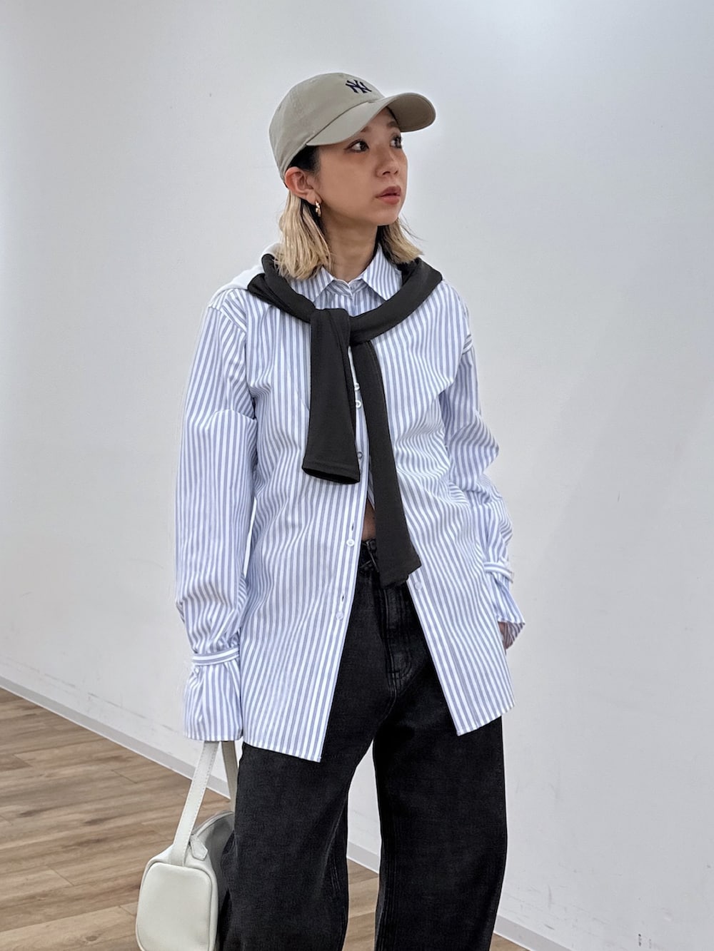 ブルー系のシャツ/ブラウス、ブラック系のデニムパンツ、ホワイト系のハンドバッグを着用したレディースの冬コーディネートの4枚目の写真