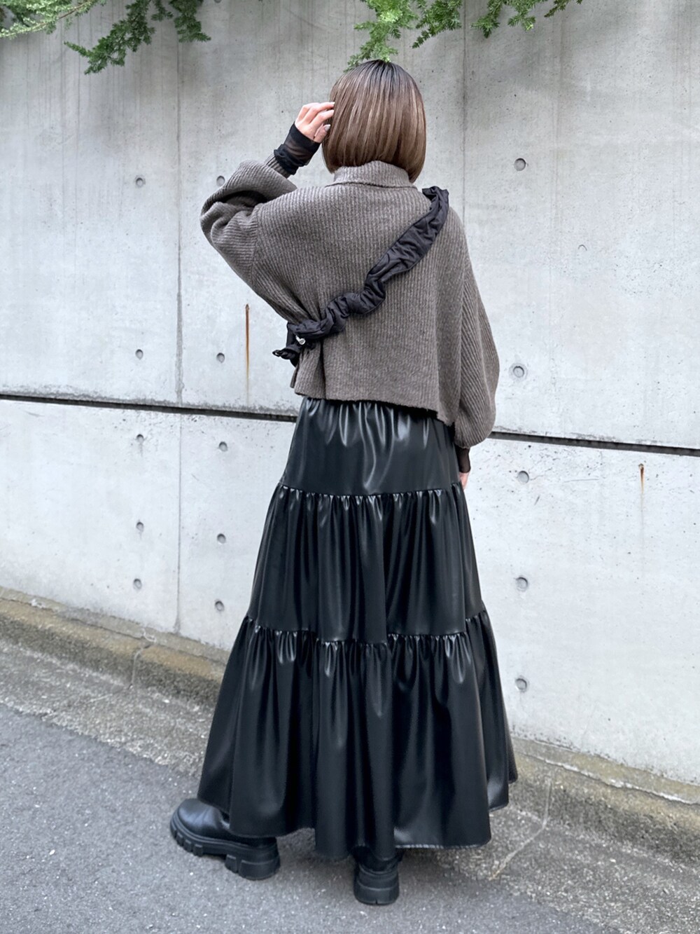 ブラック系のショルダーバッグ、ブラウン系のワンピース、ブラック系のスカートを着用したレディースの秋コーディネートの3枚目の写真