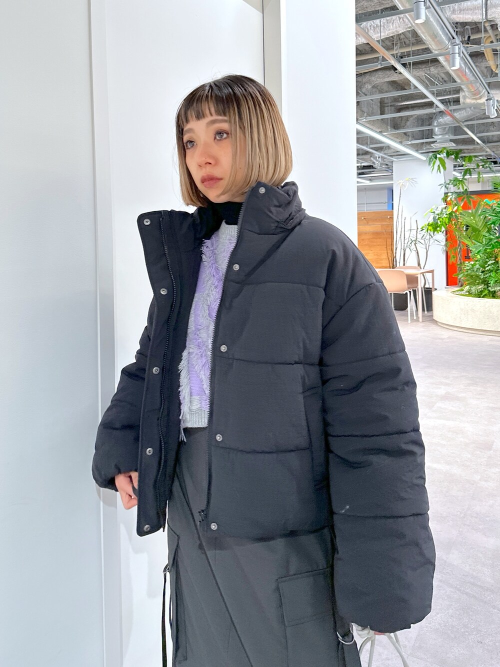 ブラック系のブルゾン、パープル系のニット/セーター、グレー系のスカートを着用したレディースの冬コーディネートの4枚目の写真