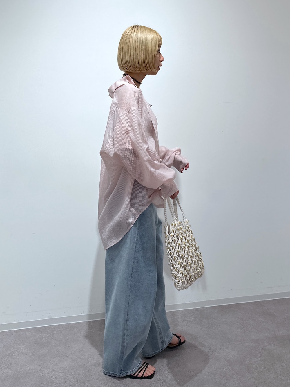 ピンク系のシャツ/ブラウス、グレー系のキャミソール、ブルー系のデニムパンツを着用したレディースの春コーディネートの2枚目の写真