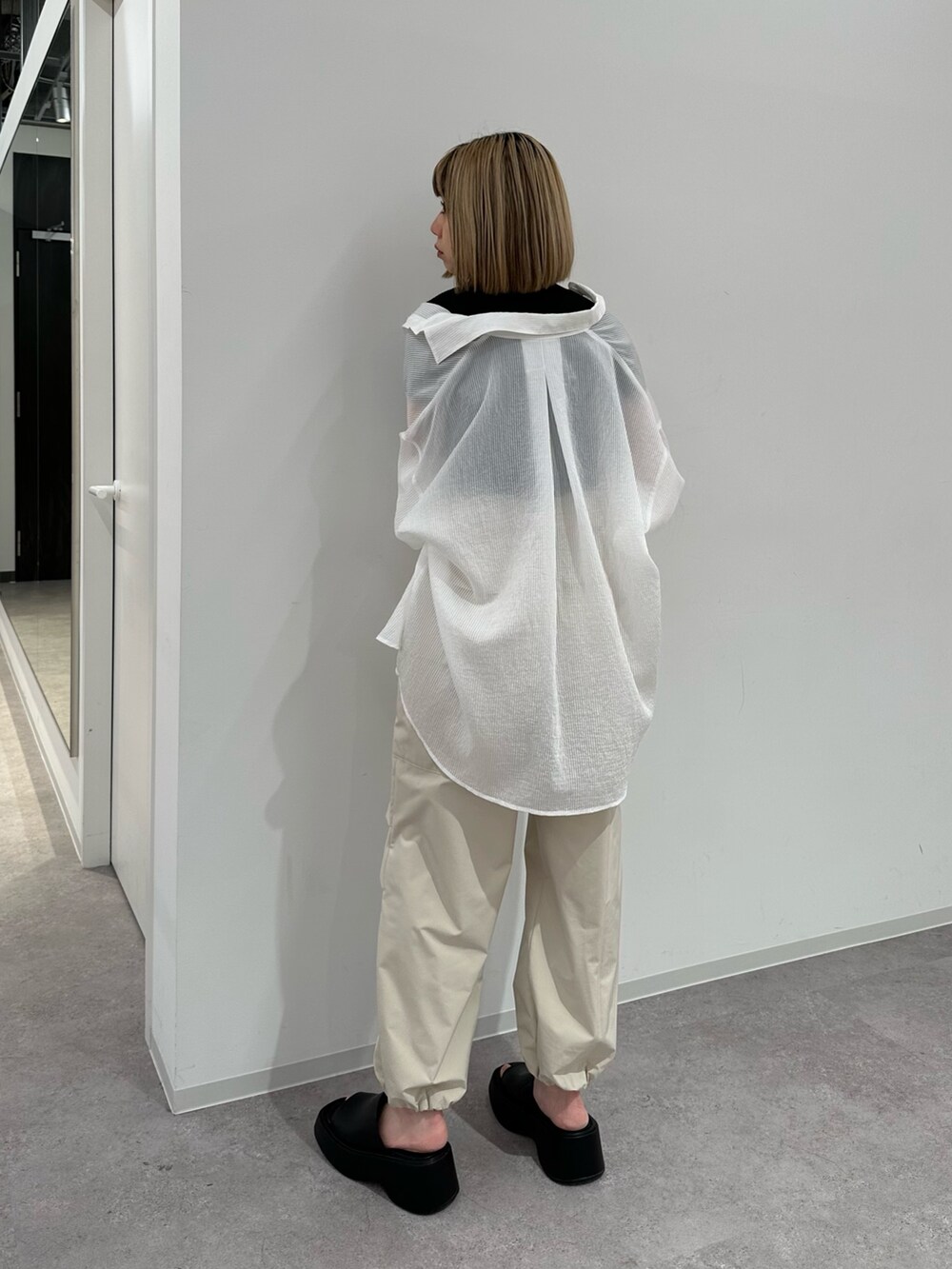 ブラック系のニット/セーター、ホワイト系のシャツ/ブラウス、ベージュ系のカーゴパンツを着用したレディースの夏コーディネートの3枚目の写真