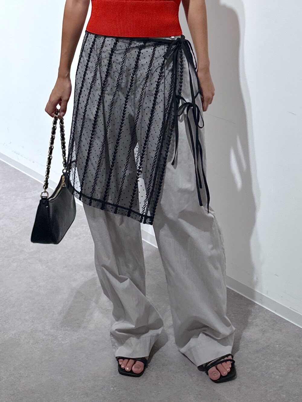 ブラック系のスカート、レッド系のニット/セーター、グレー系のその他パンツを着用したレディースの夏コーディネートの5枚目の写真