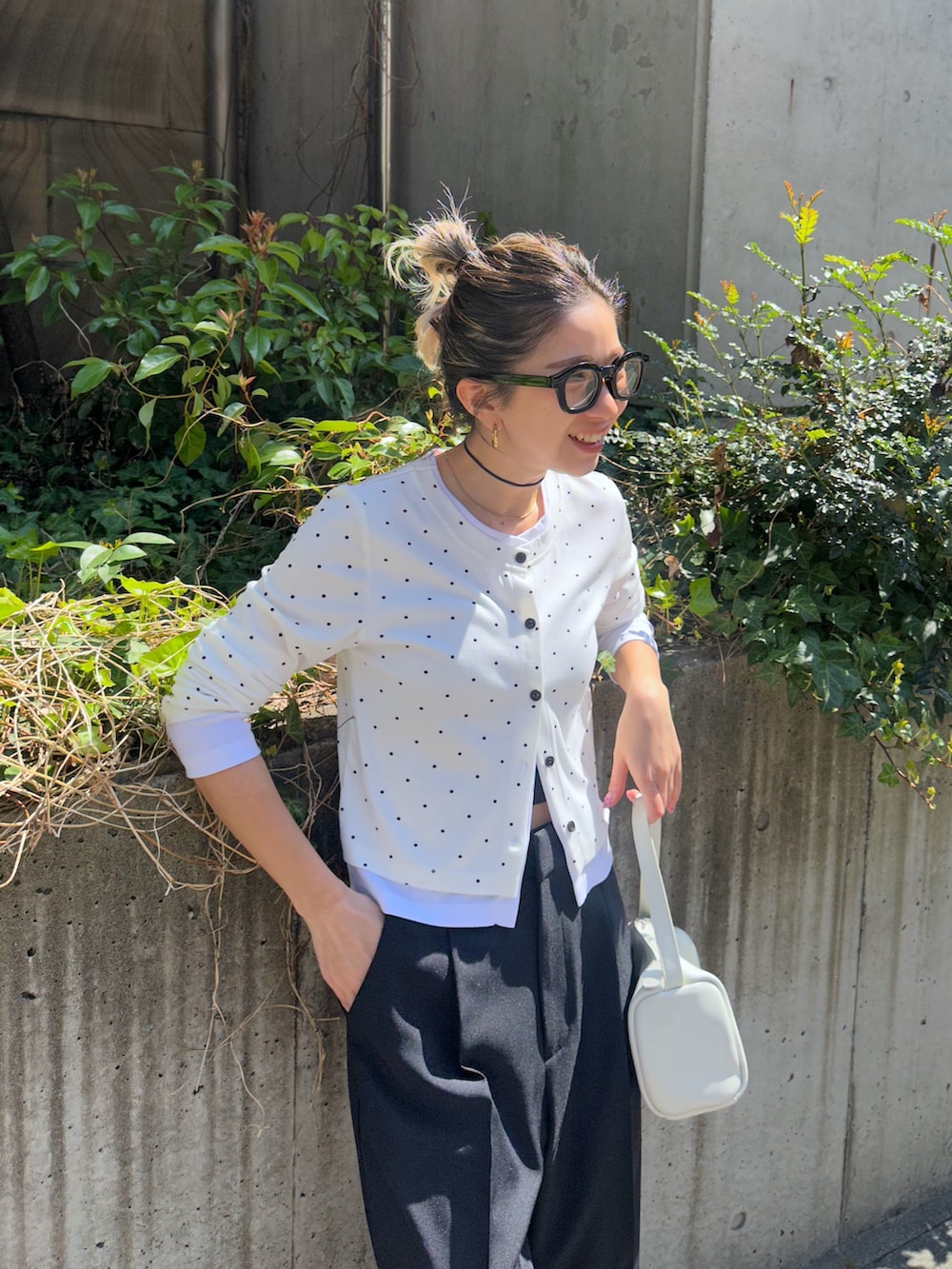 ホワイト系のTシャツ/カットソー、ブラック系のスラックス、ホワイト系のハンドバッグを着用したレディースの春コーディネートの4枚目の写真