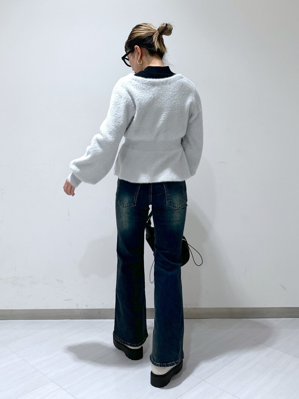 グレー系のカーディガン/ボレロ、ブラック系のニット/セーター、ブルー系のデニムパンツを着用したレディースの冬コーディネートの3枚目の写真