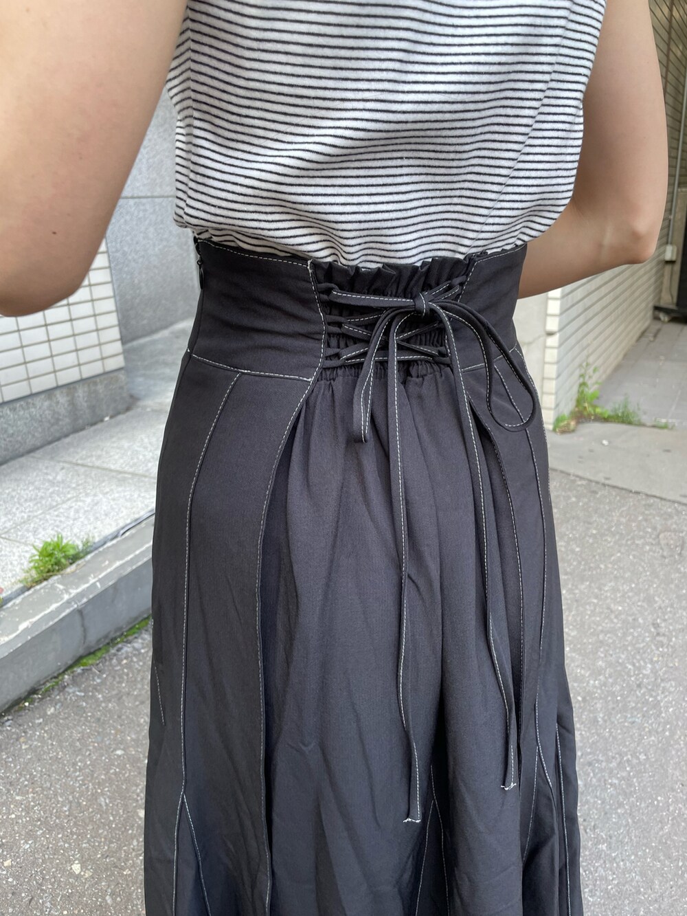 ピンク系のシャツ/ブラウス、ブラック系のスカート、ホワイト系のサンダルを着用したレディースの夏コーディネートの3枚目の写真