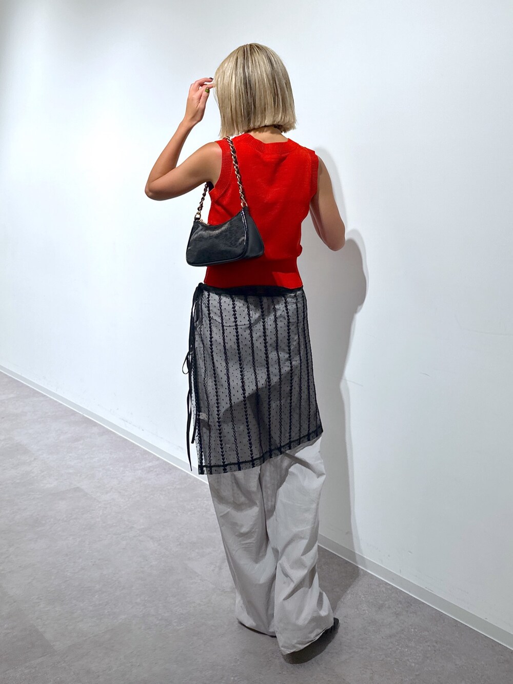 ブラック系のスカート、レッド系のニット/セーター、グレー系のその他パンツを着用したレディースの夏コーディネートの3枚目の写真