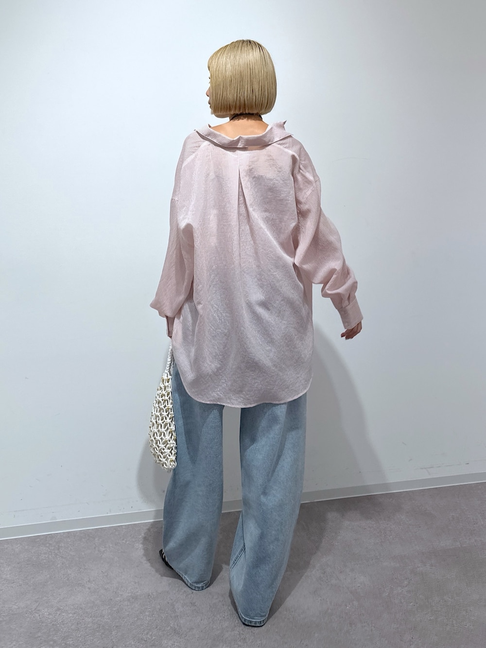 ピンク系のシャツ/ブラウス、グレー系のキャミソール、ブルー系のデニムパンツを着用したレディースの春コーディネートの3枚目の写真